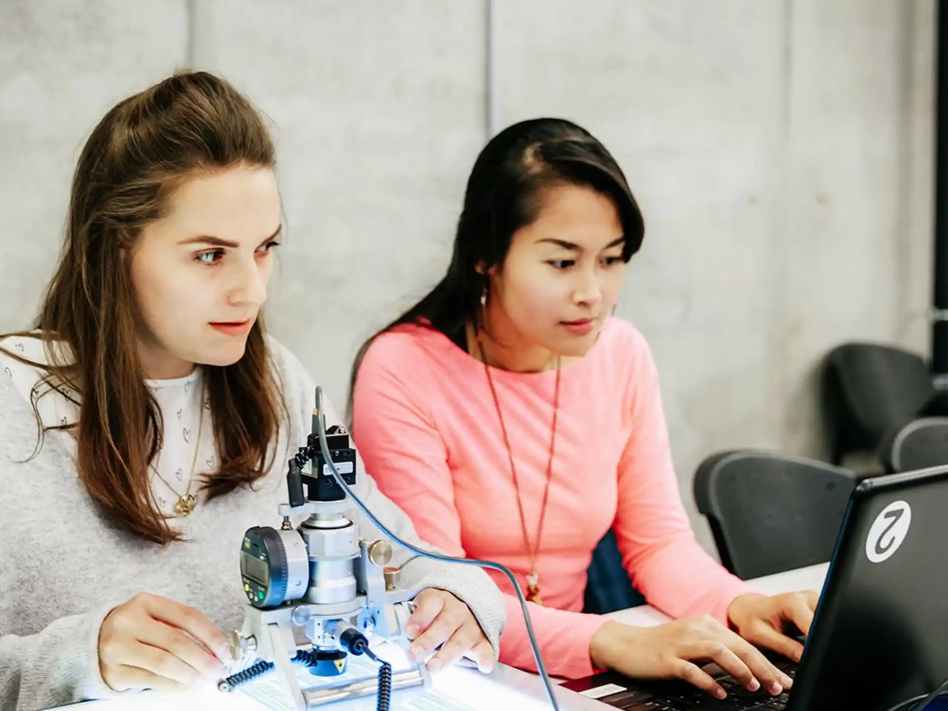 a couple of women working on a laptop