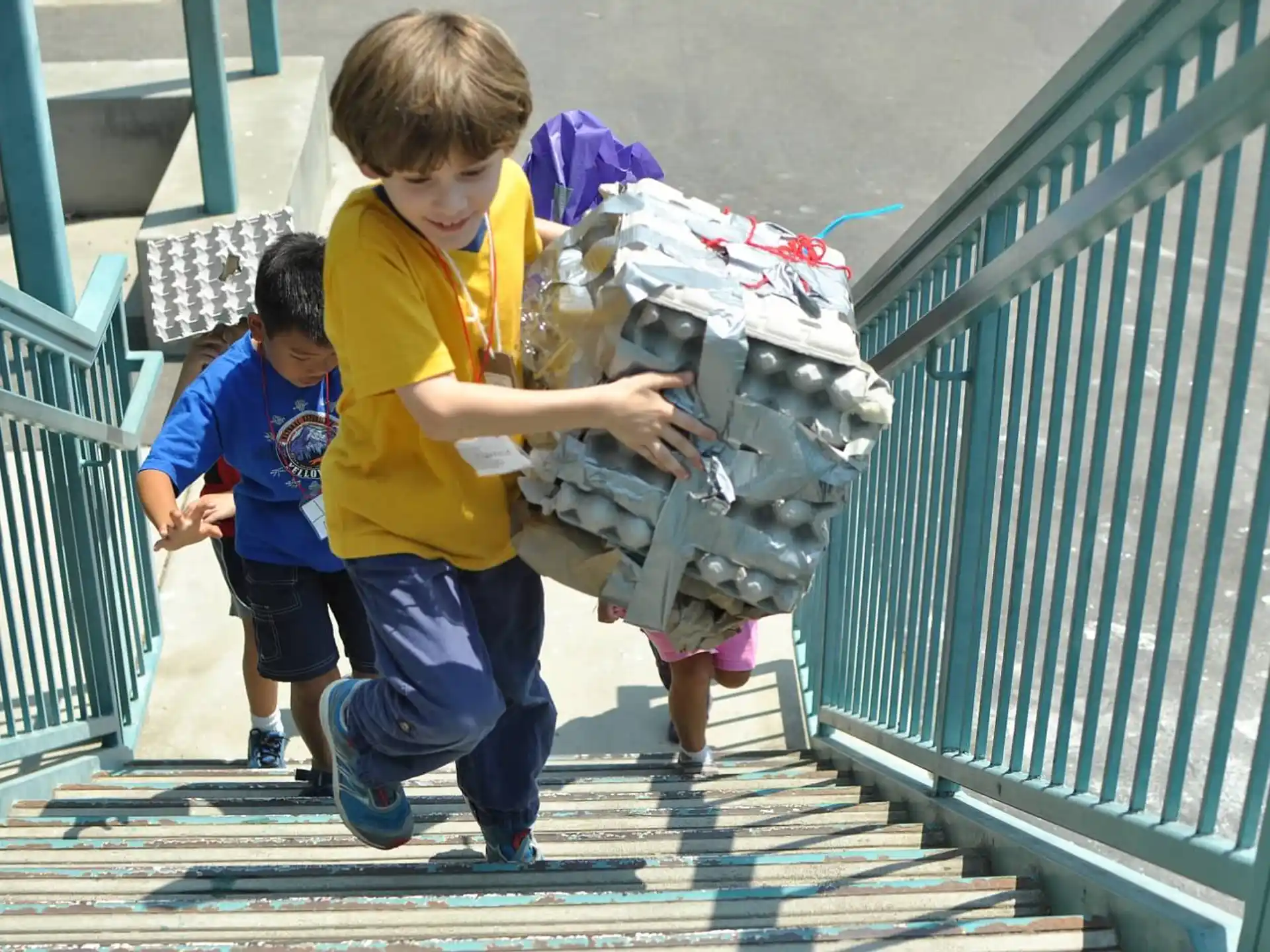 a couple of kids carrying a baby
