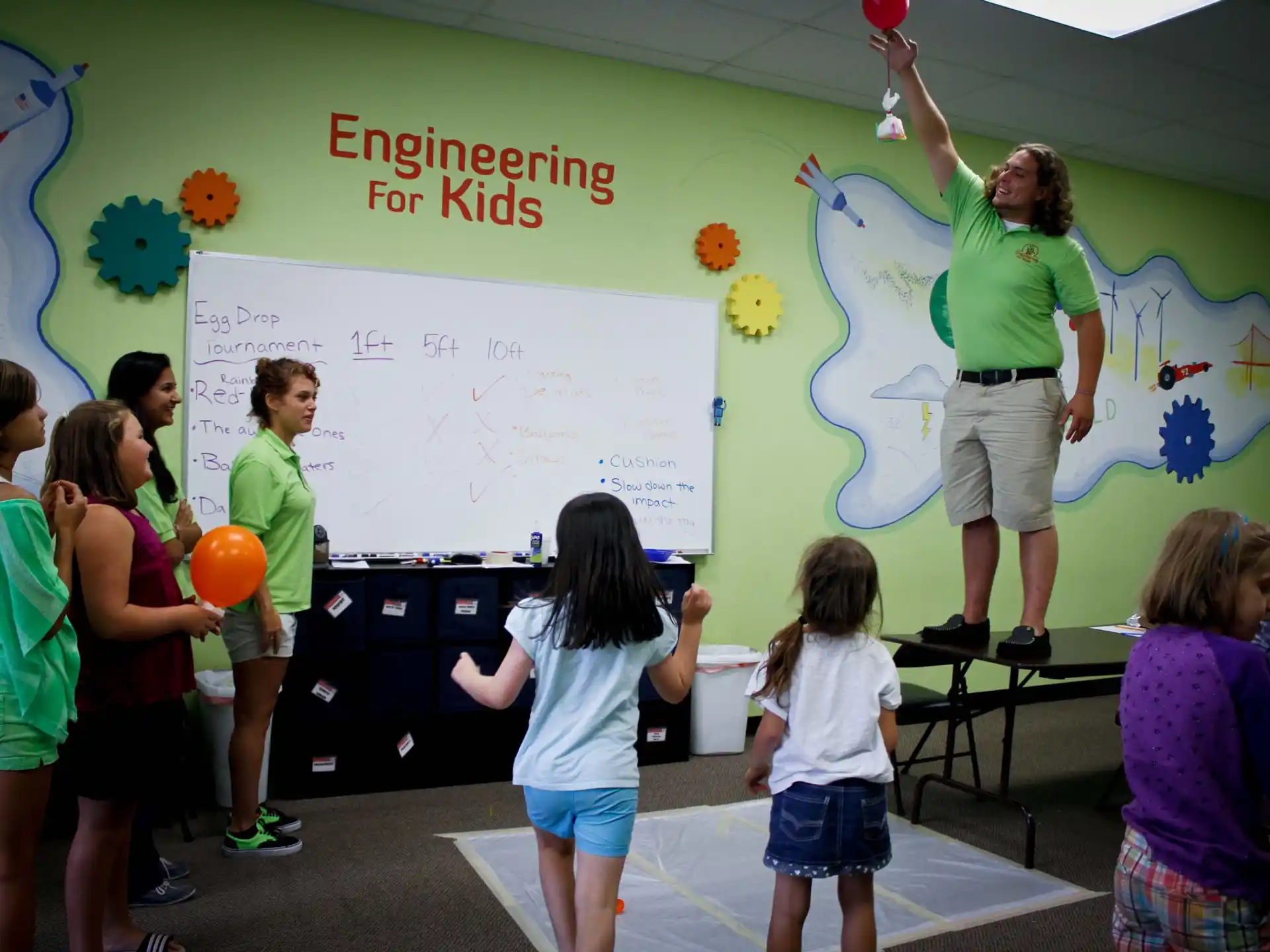 a group of children playing with a person in a classroom