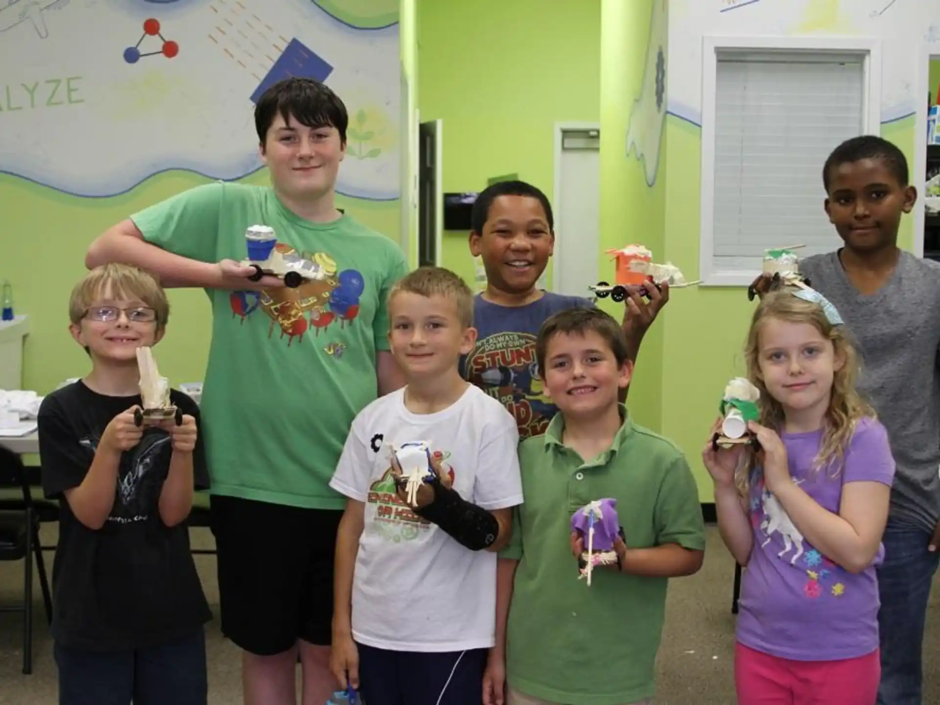 a group of people holding objects posing for the camera