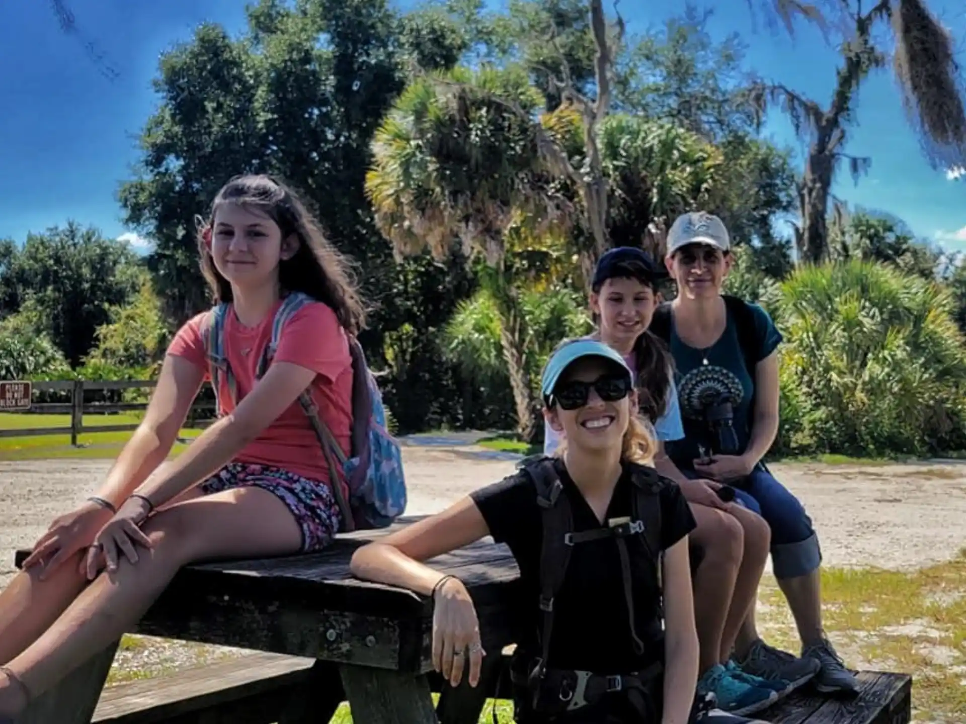 a group of people sitting on a bench in a park