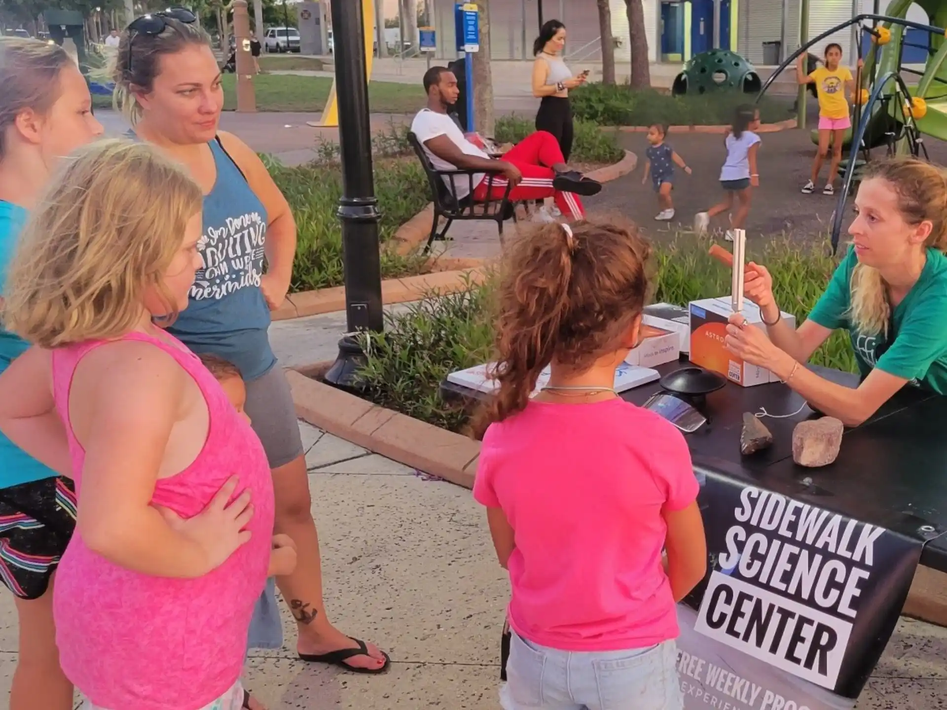 a group of people standing around a table outside