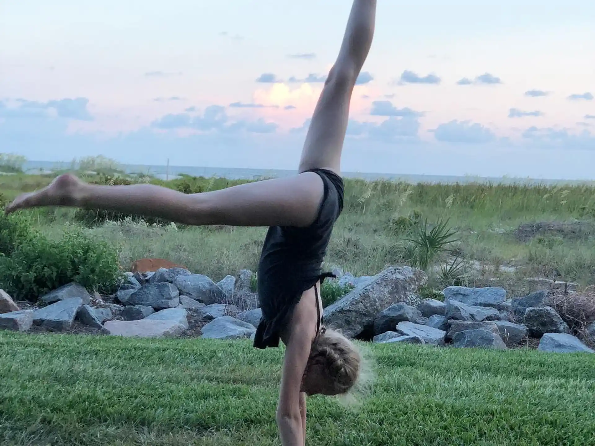 a man doing a handstand on grass