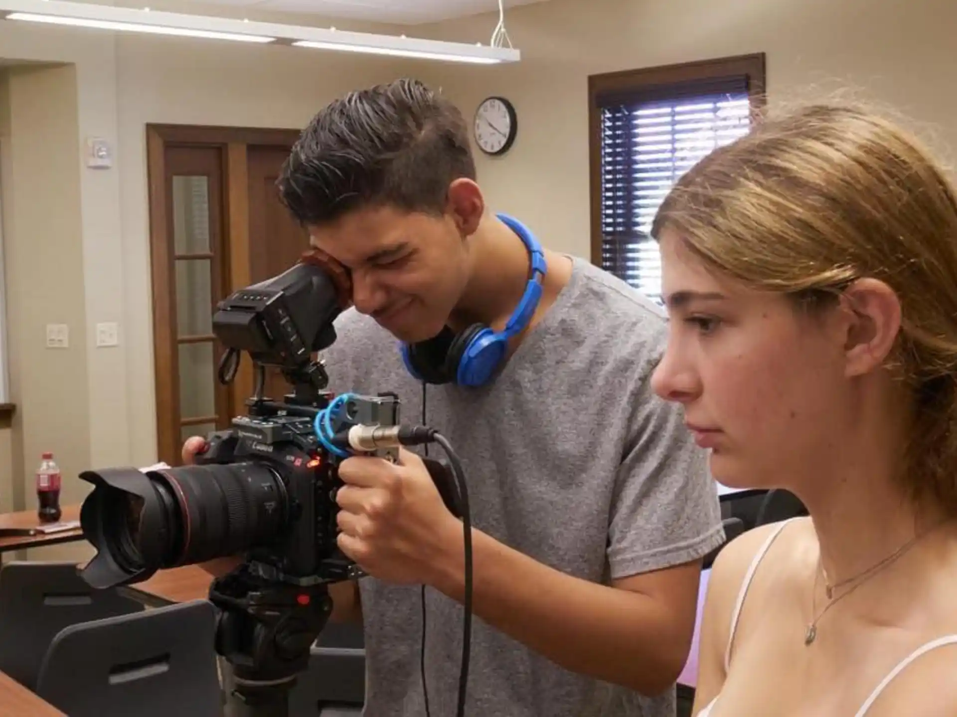 a man and a woman looking through a camera