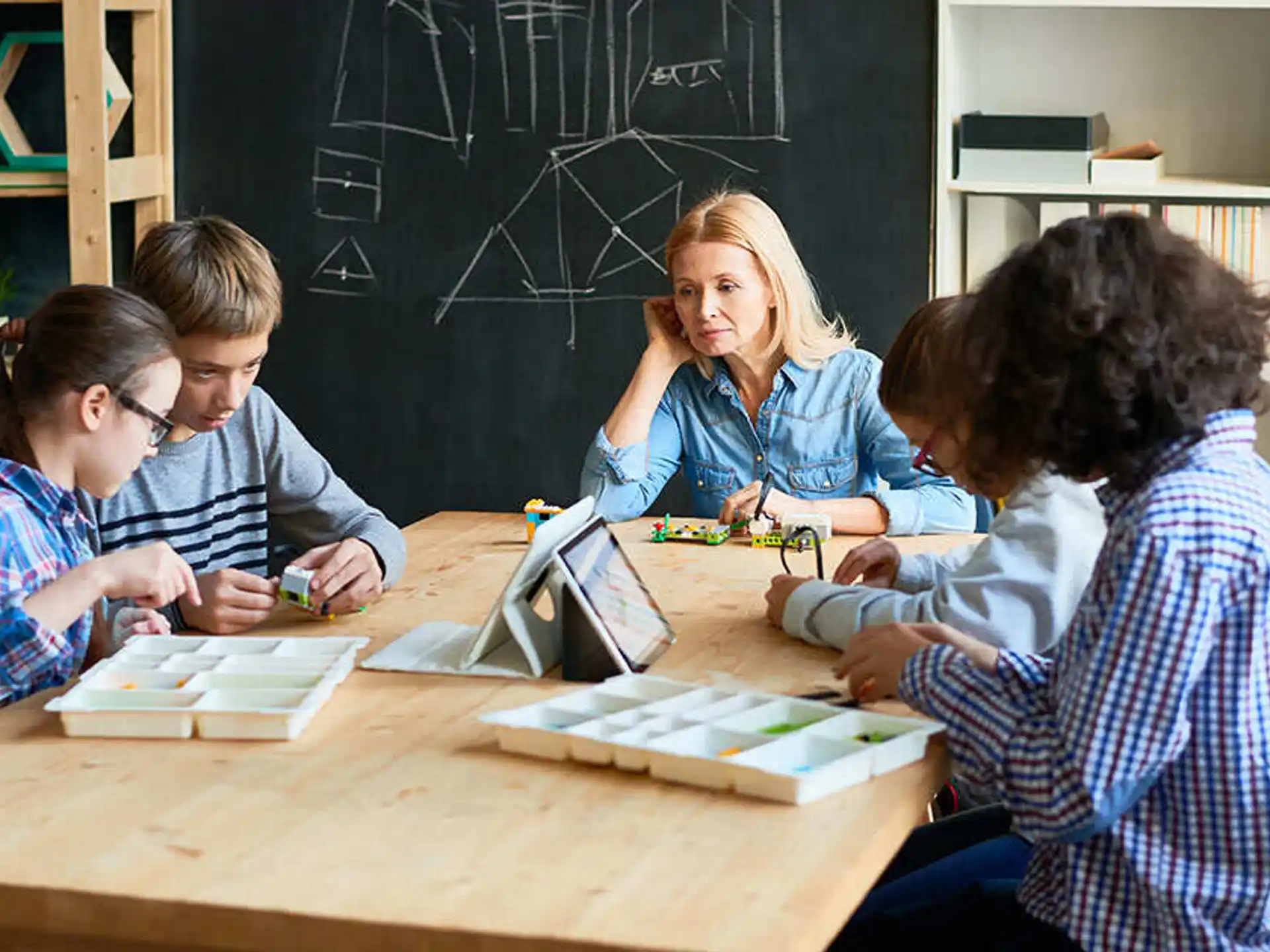 a group of people sitting at a table looking at a book