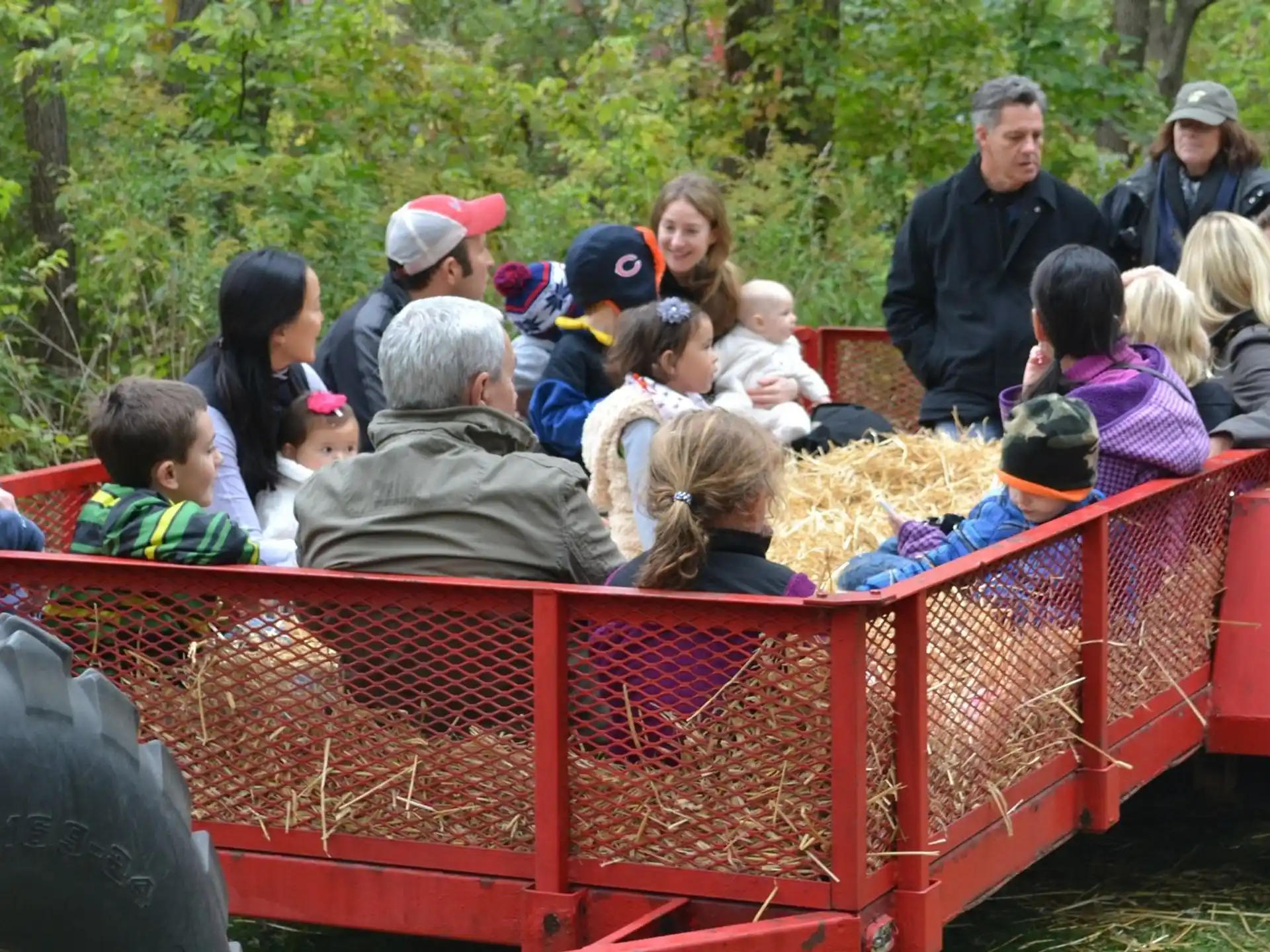 a group of people sitting in a red tractor