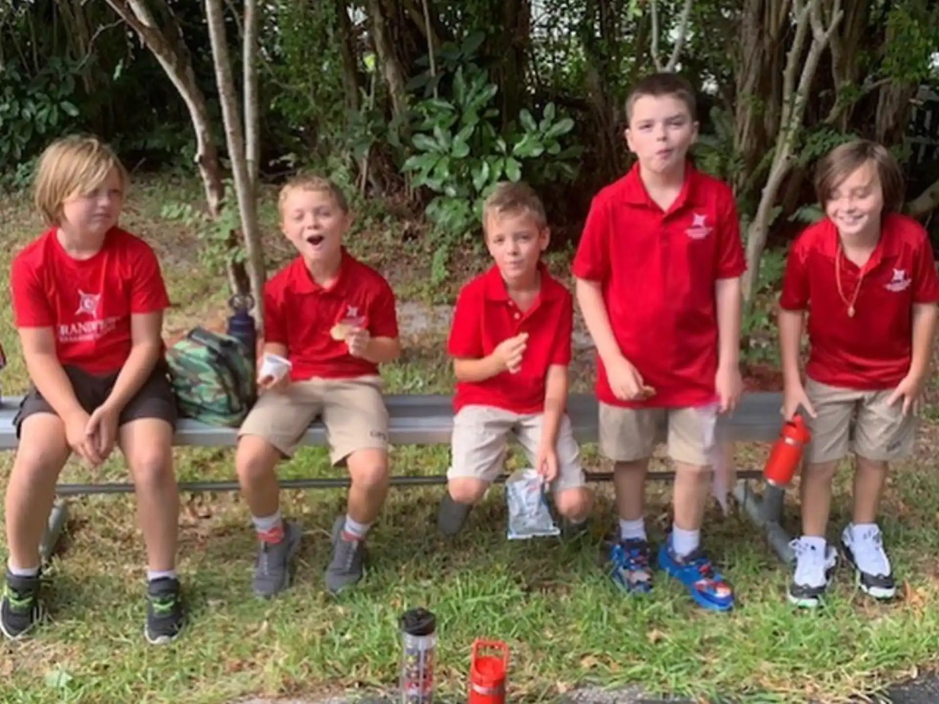 a group of boys sitting on a bench