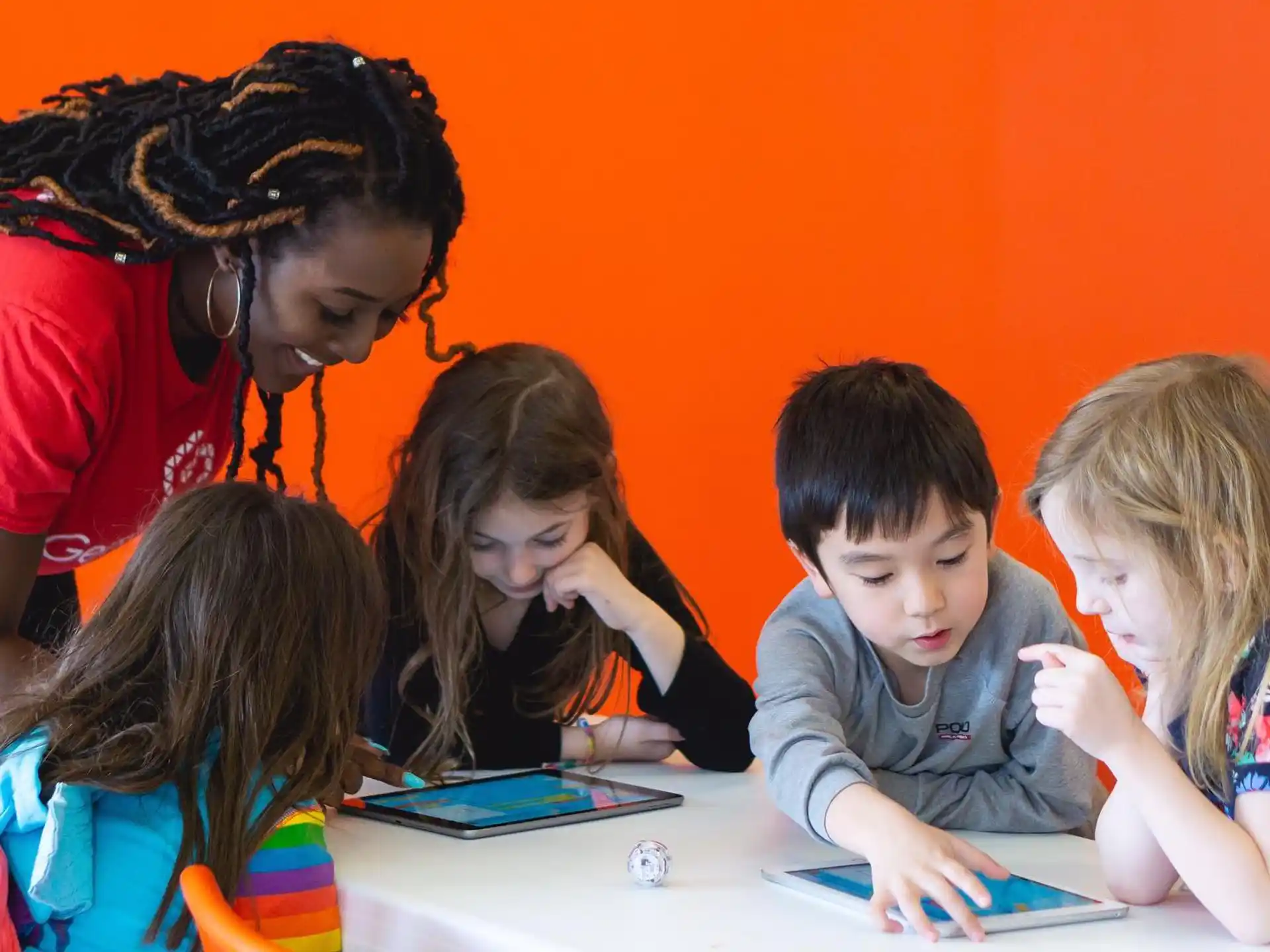 a group of children looking at a tablet