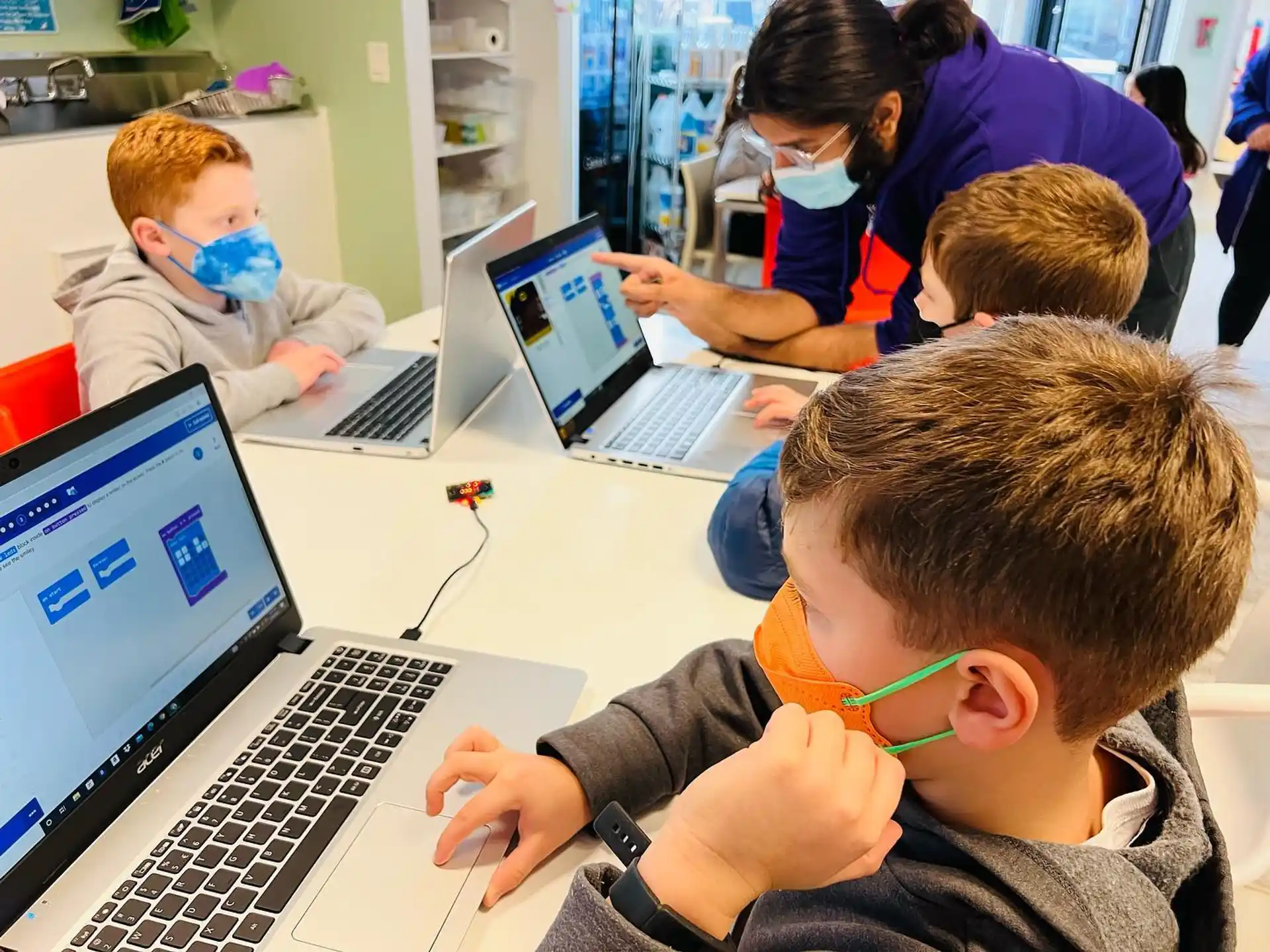 a group of children using laptops