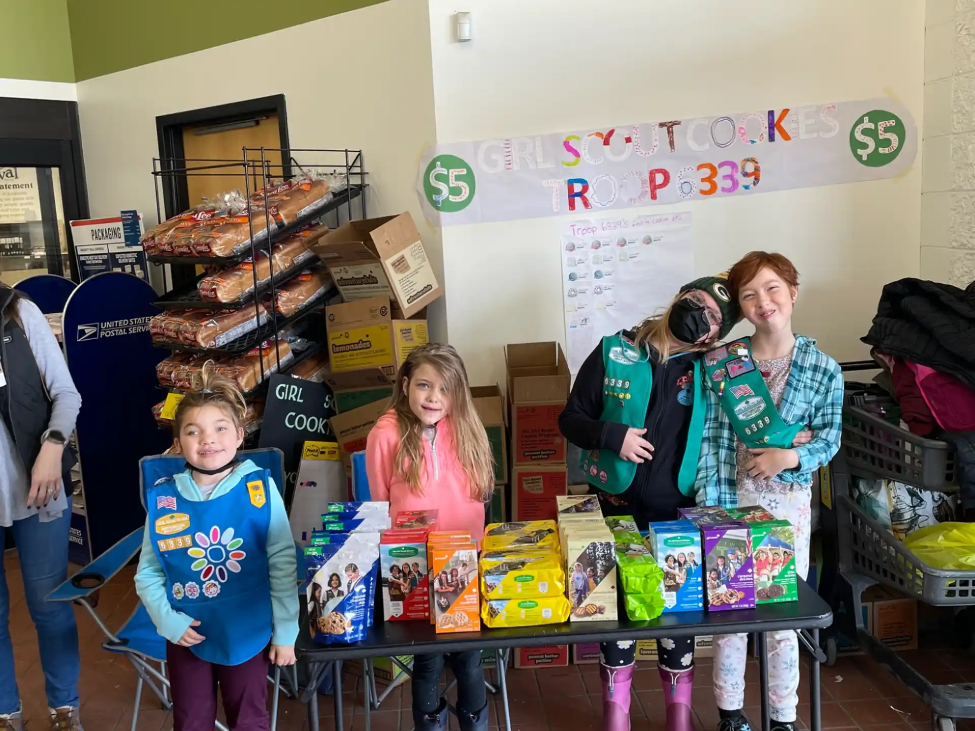a group of children standing in front of a table with boxes