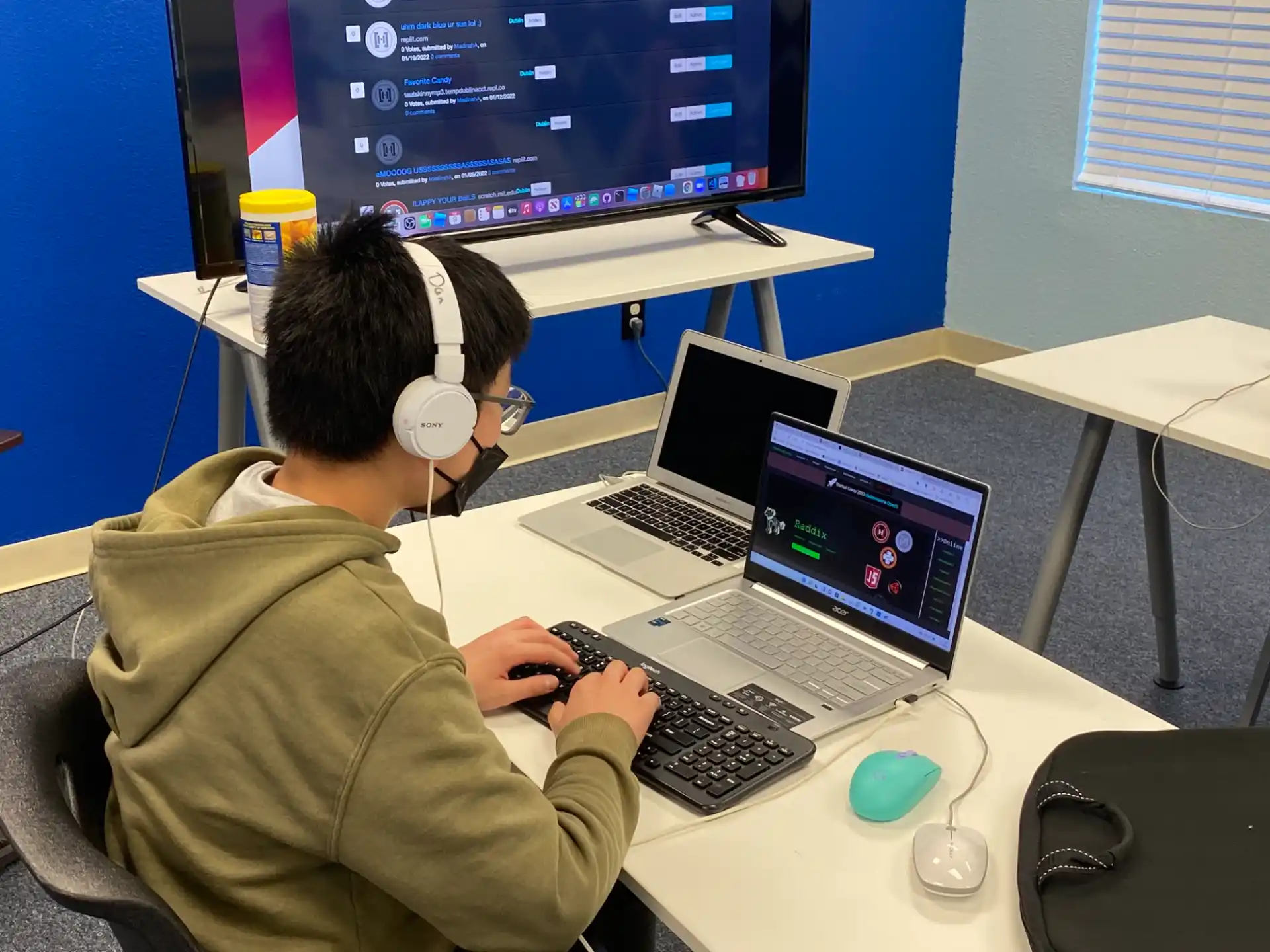 a man wearing headphones and using a laptop