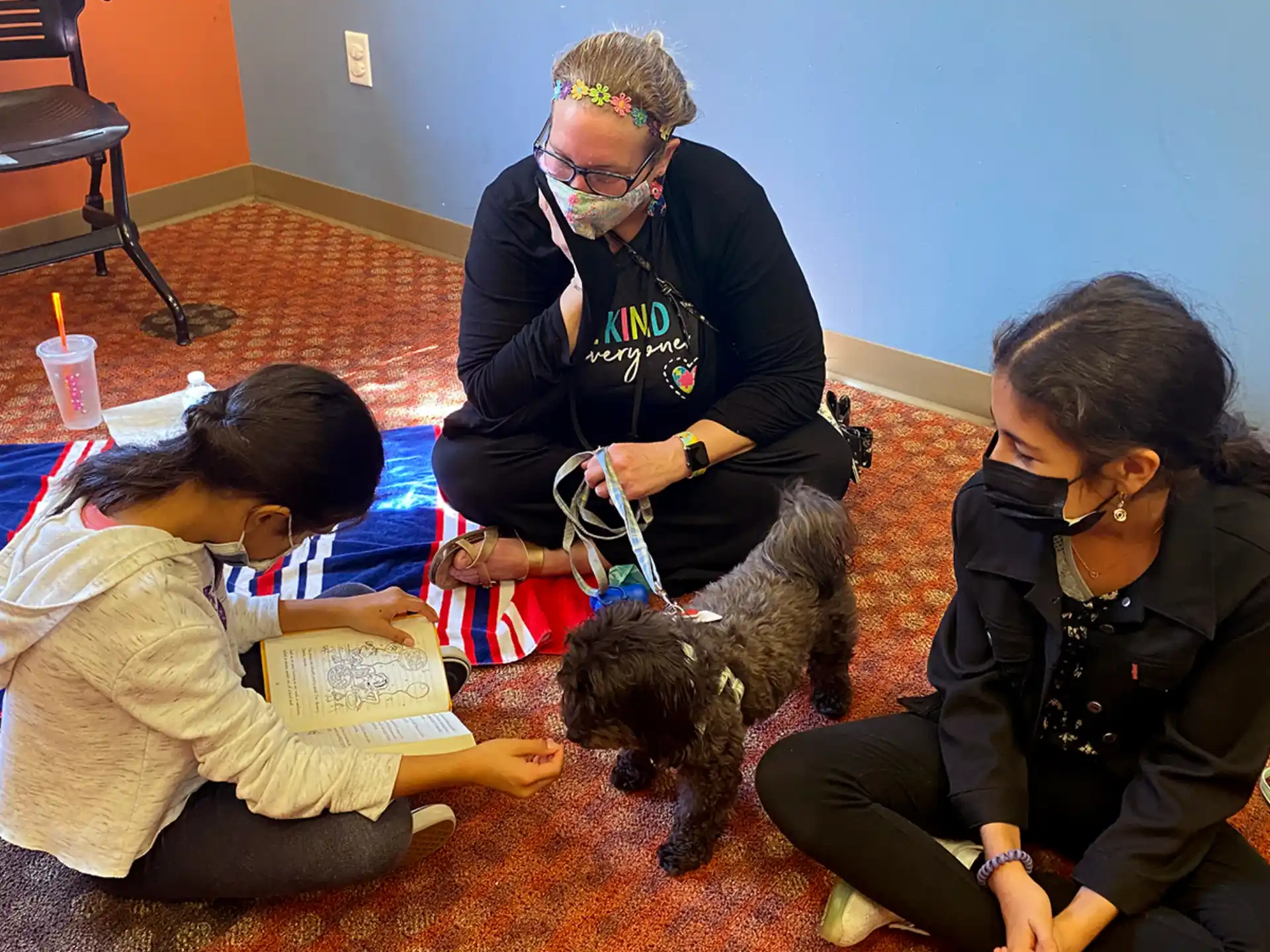 a group of people sitting on the floor with a dog
