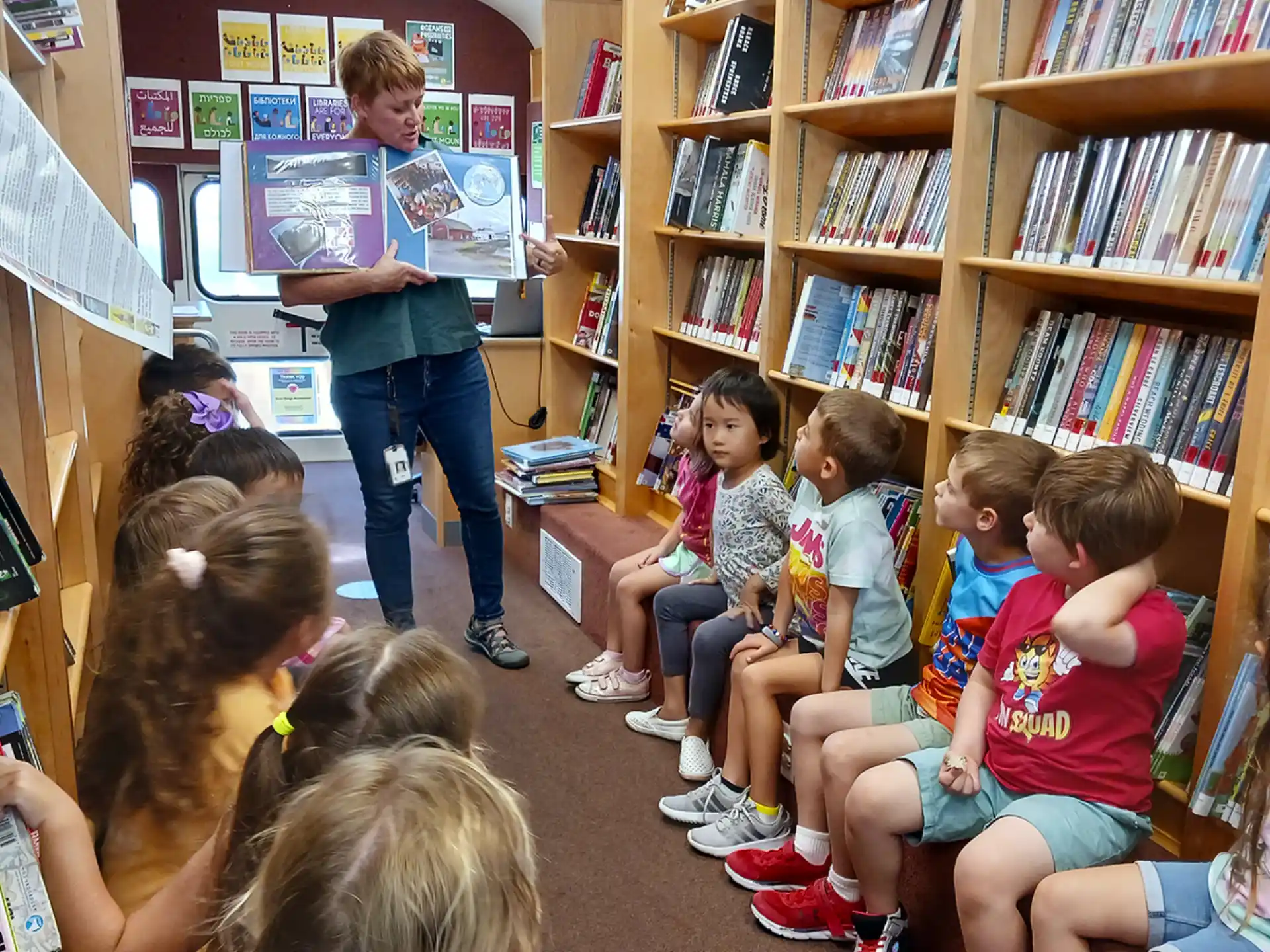 a person reading a book to a group of children