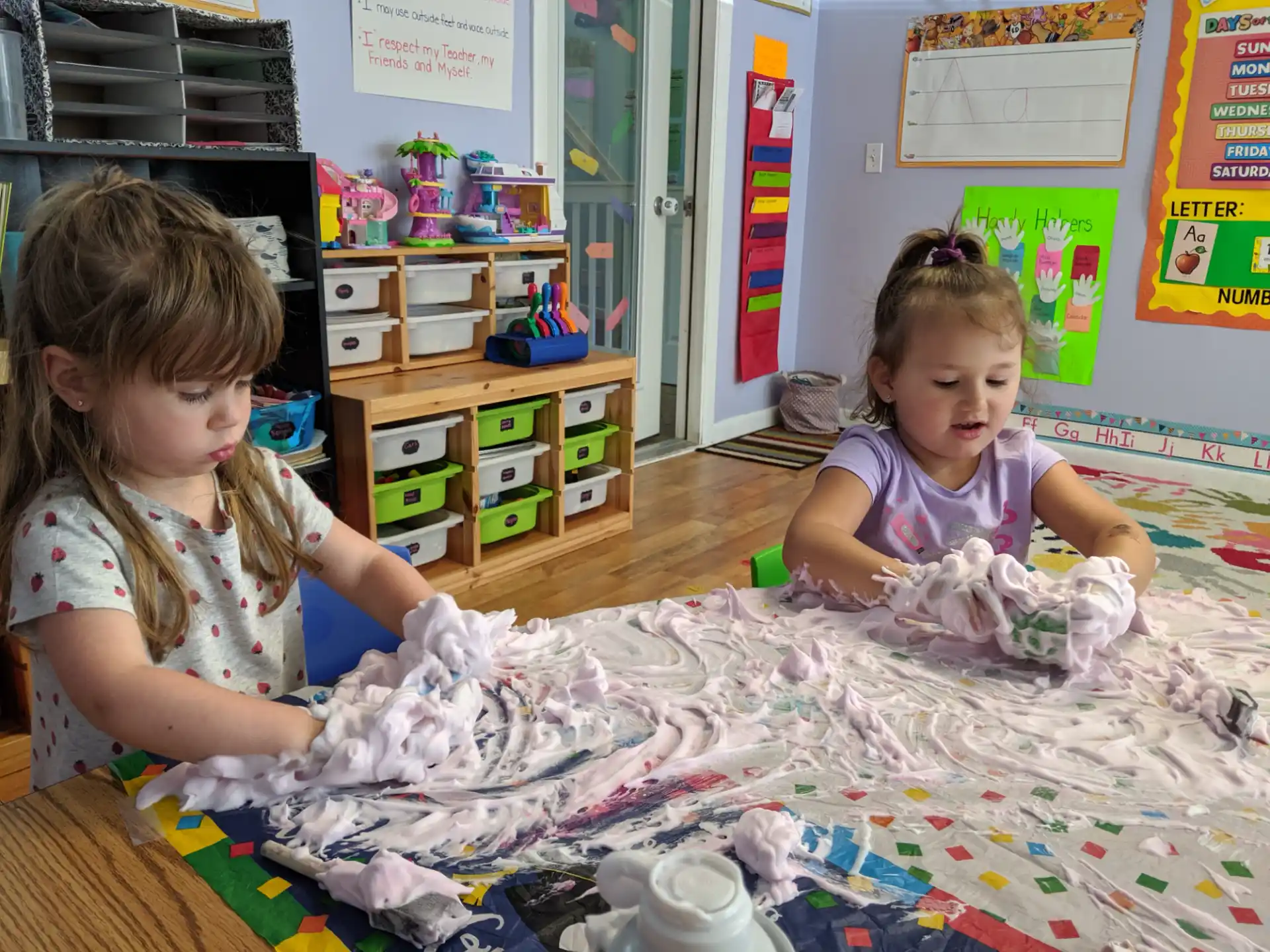 a couple of young girls playing with a toy