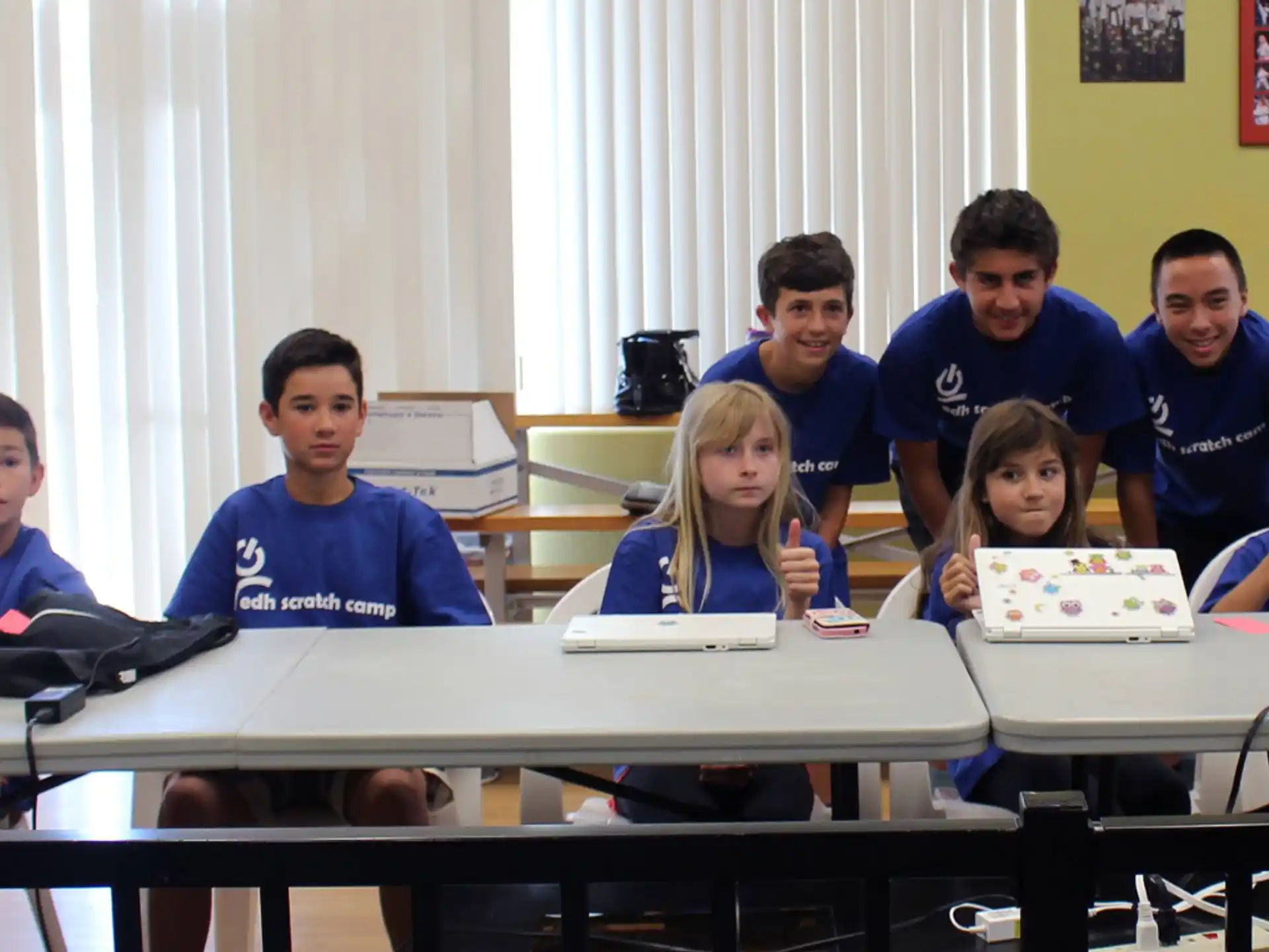 a group of people sitting at a table with a sign