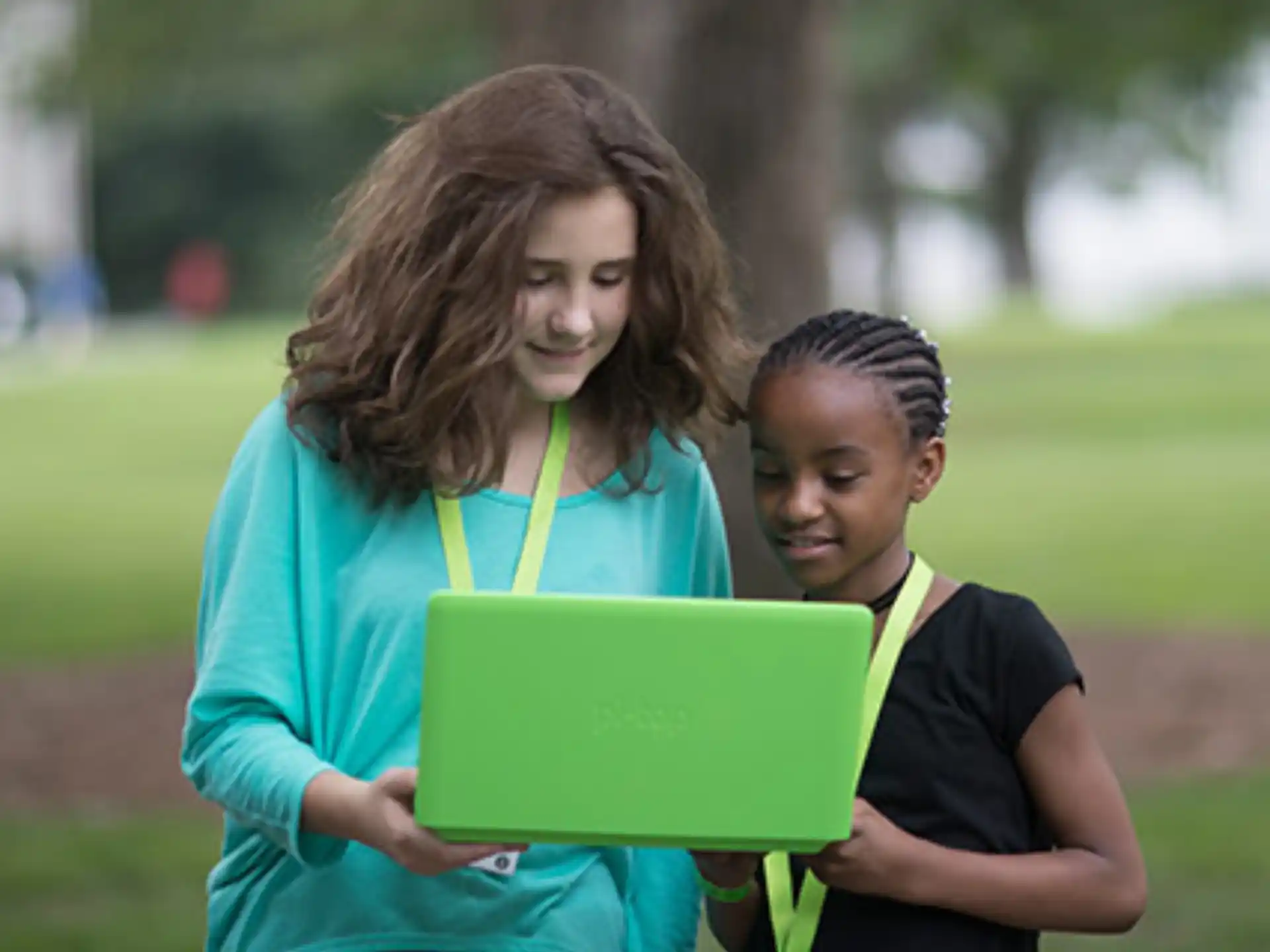 a person and a boy looking at a laptop