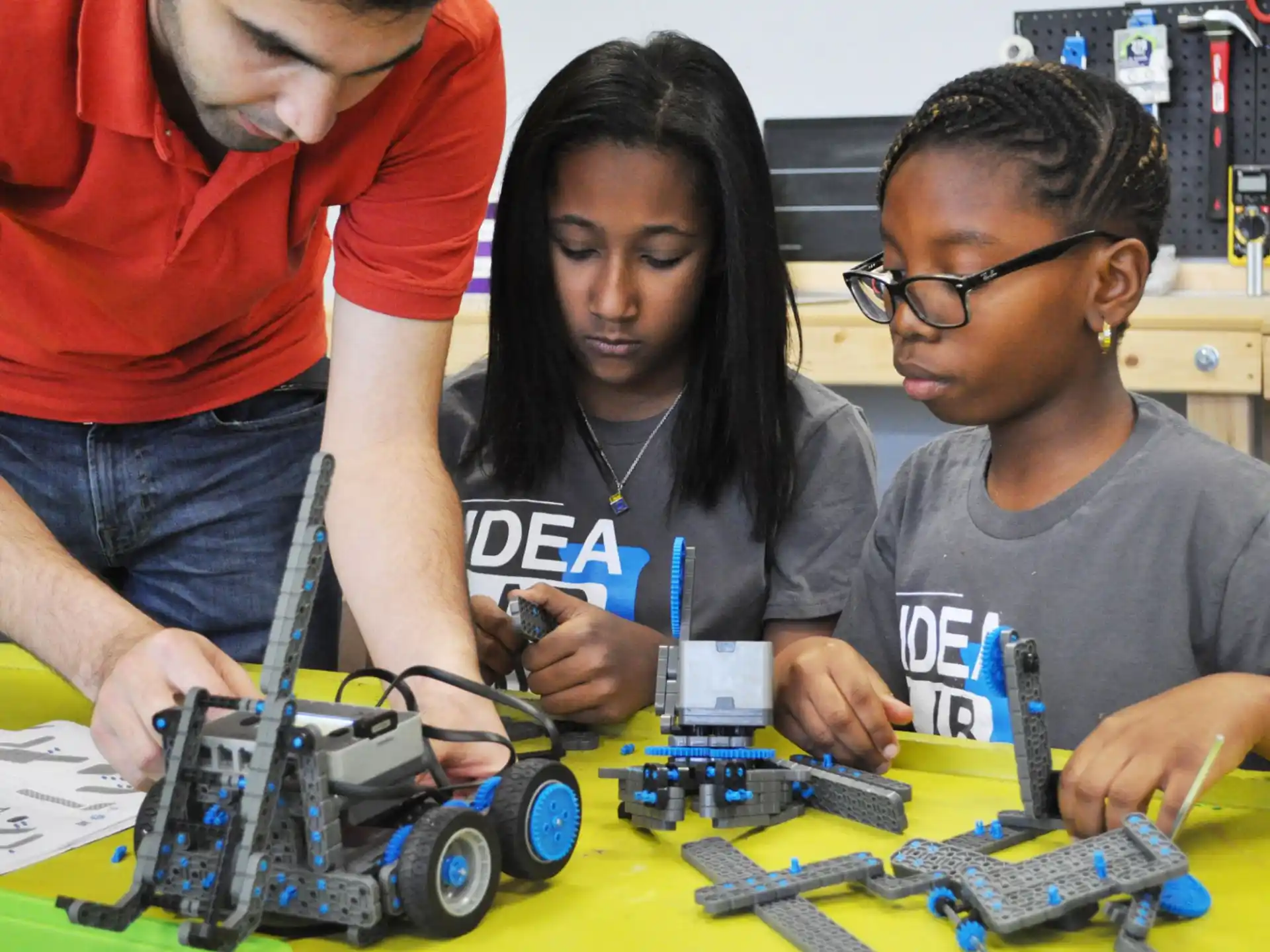 a group of people working on a toy car