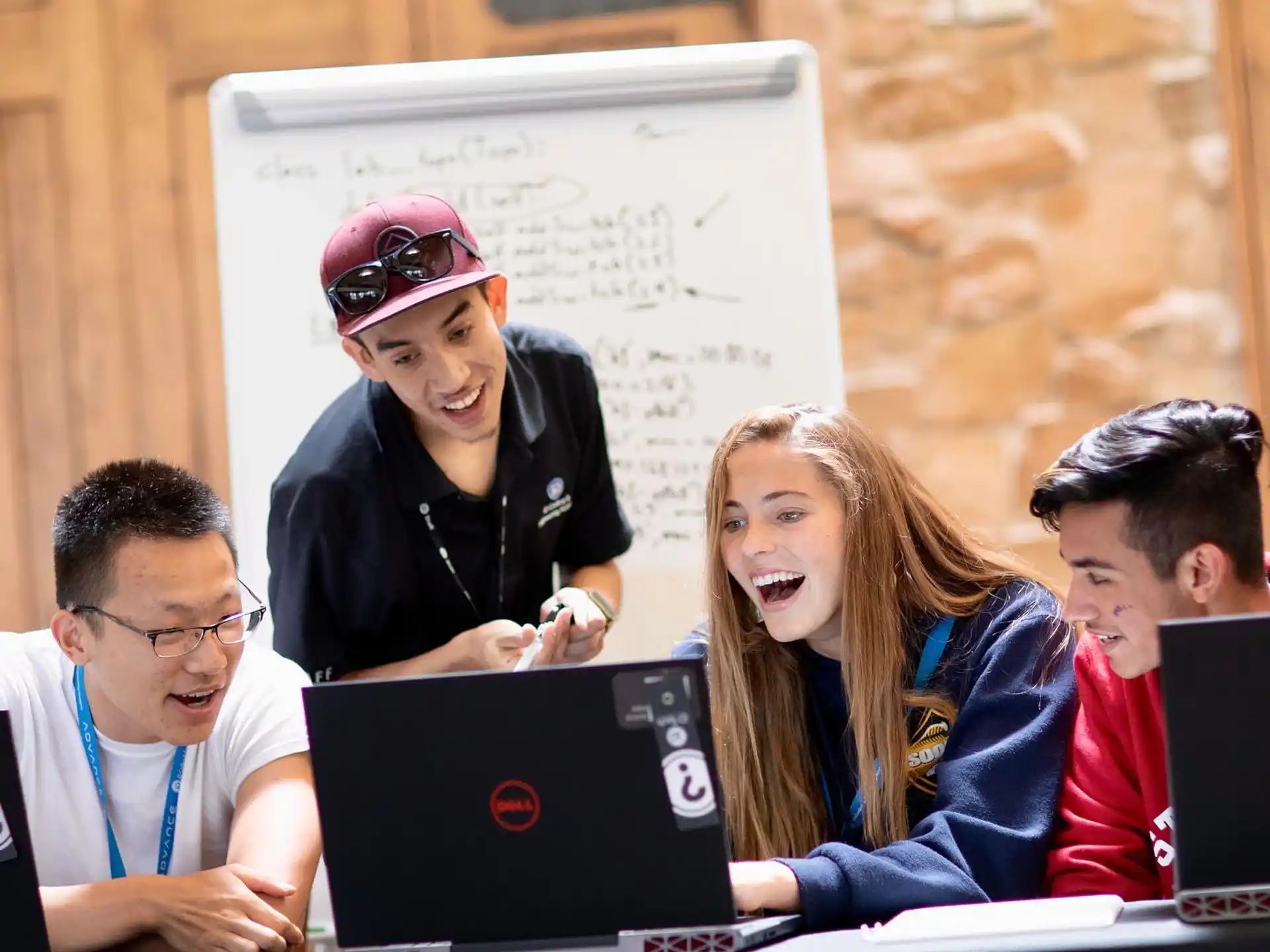a group of people sitting at a table with laptops