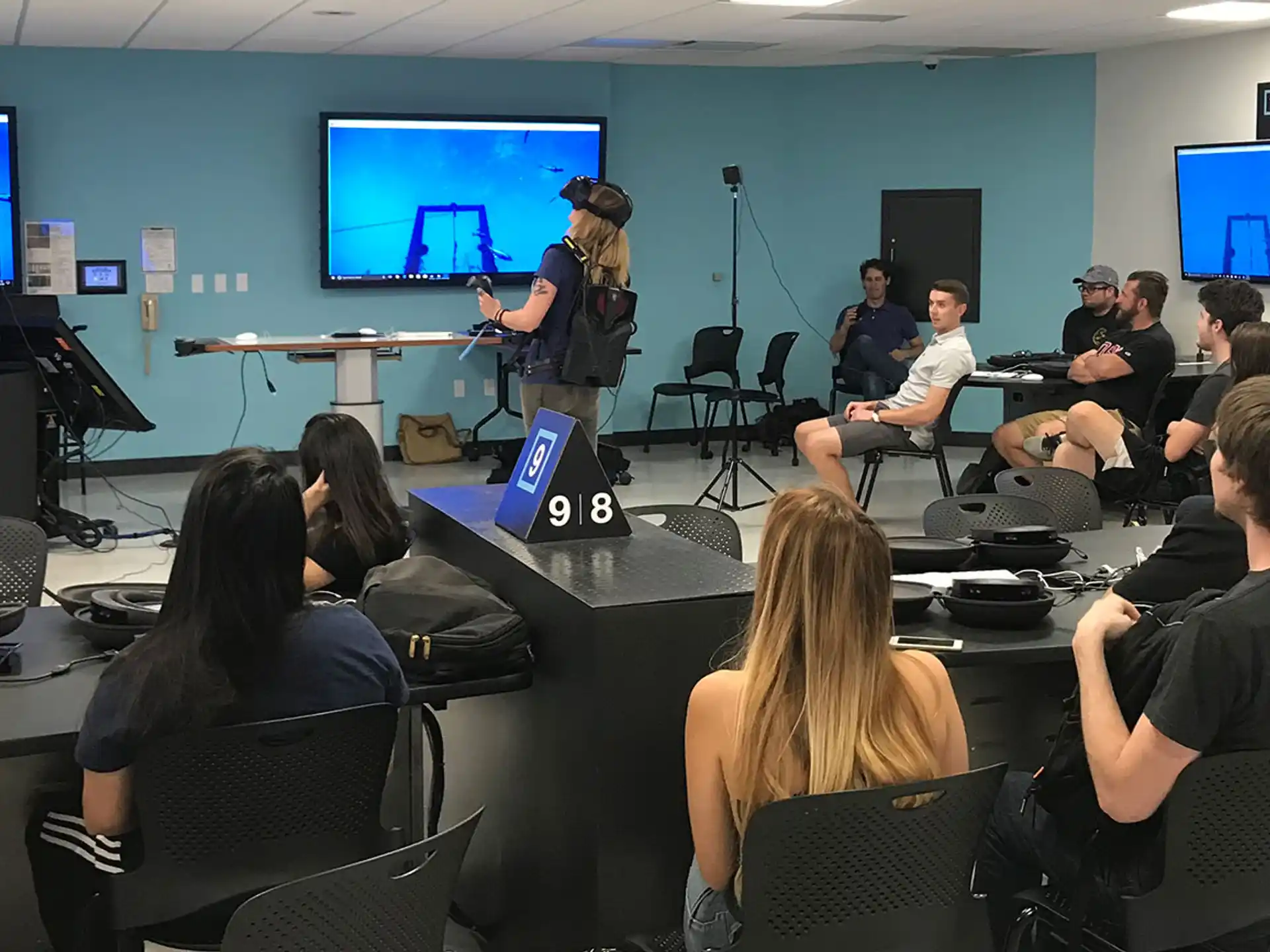 a group of people sitting in a room with computers