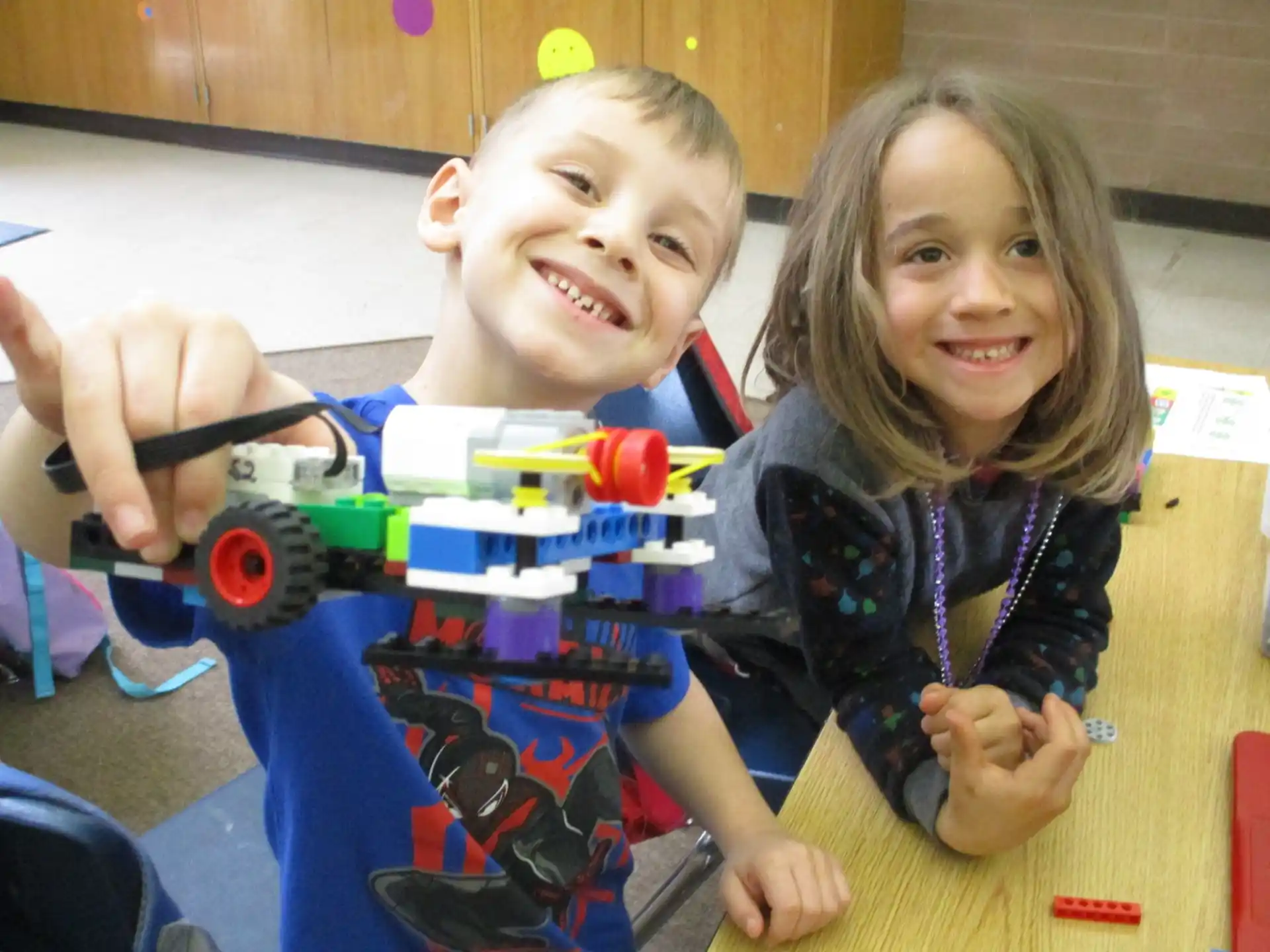 a boy and girl playing with a toy train