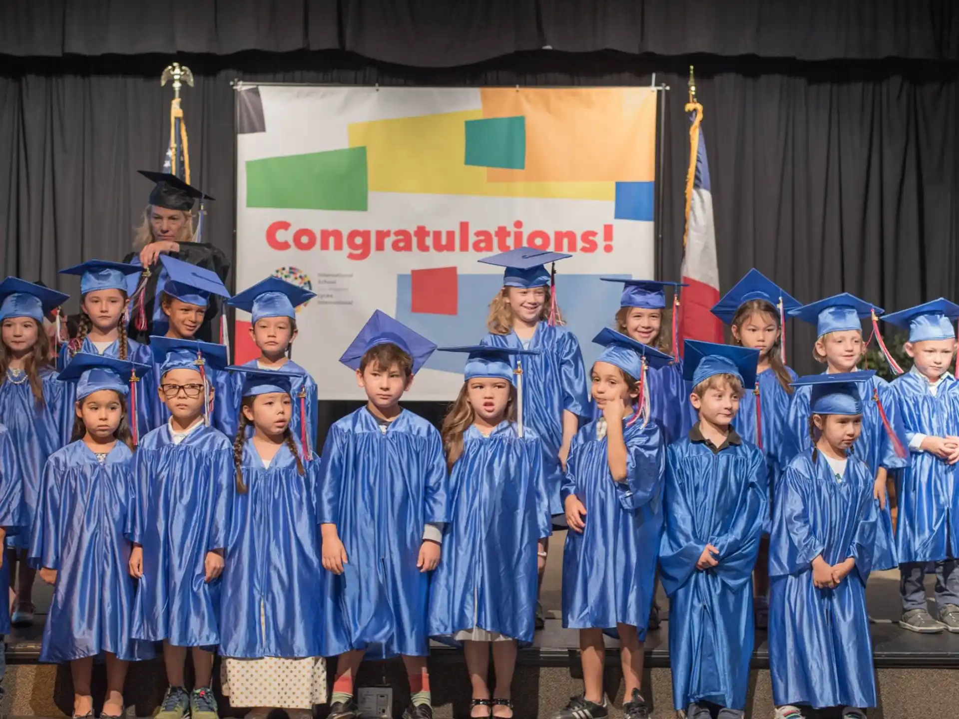 a group of children in blue graduation gowns and caps