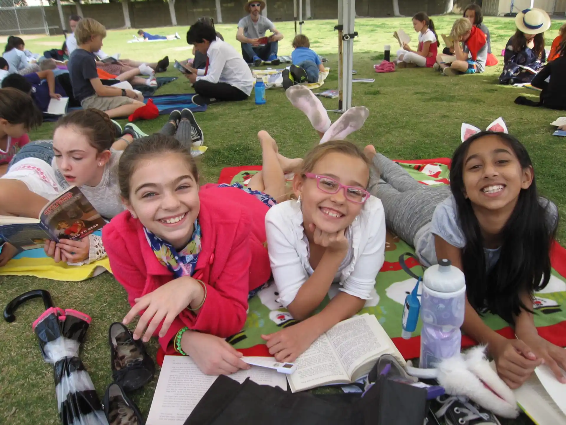 a group of children sitting on the ground and smiling