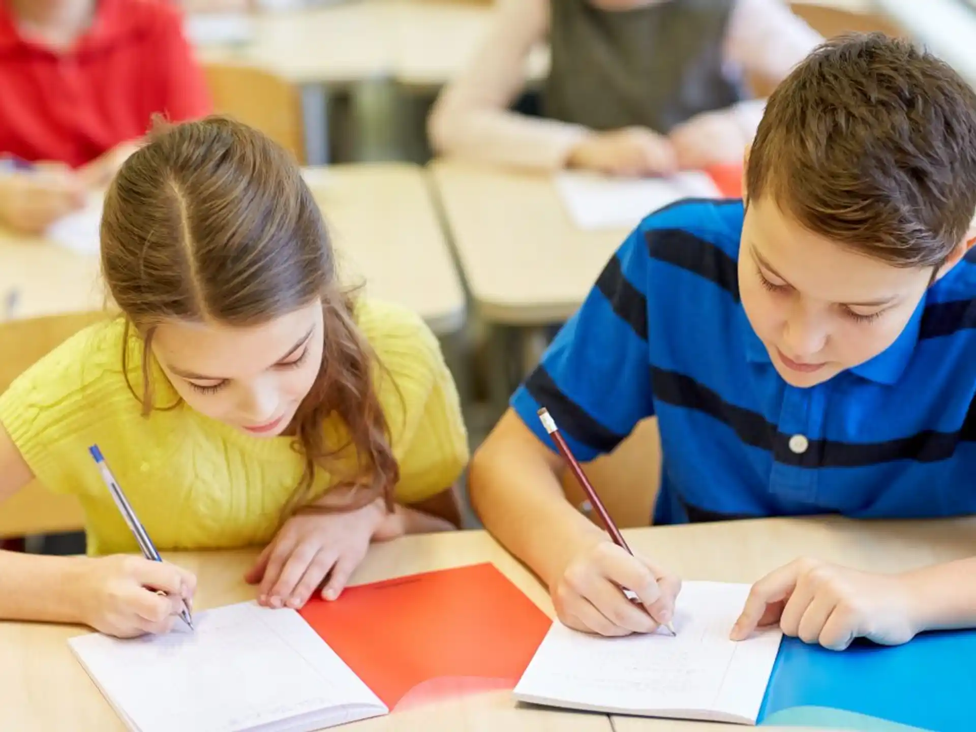 a boy and girl writing on paper