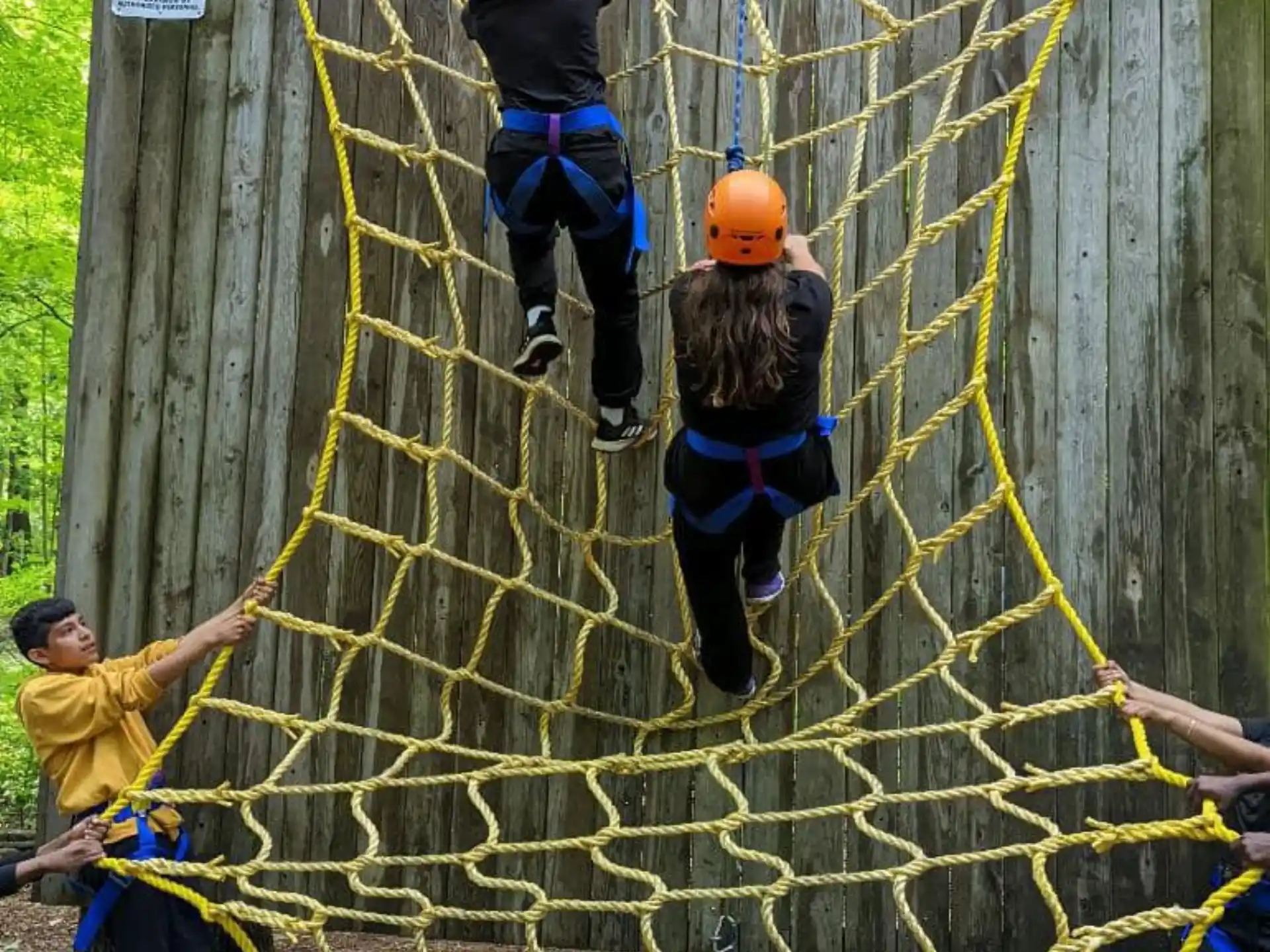 a group of people climbing a rope