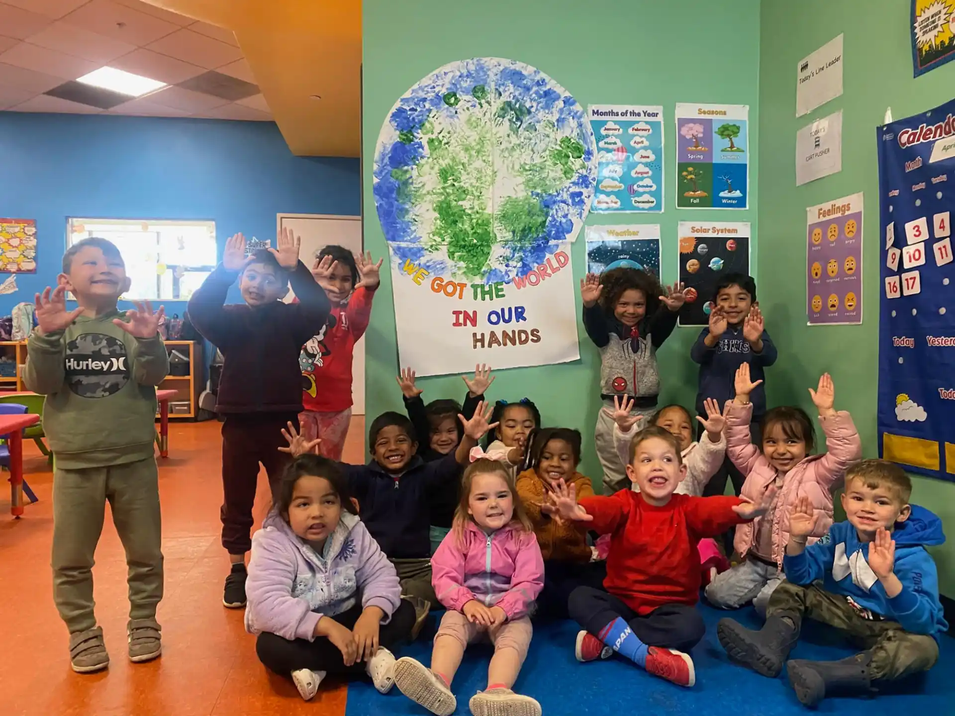 a group of children posing for a photo in front of a globe