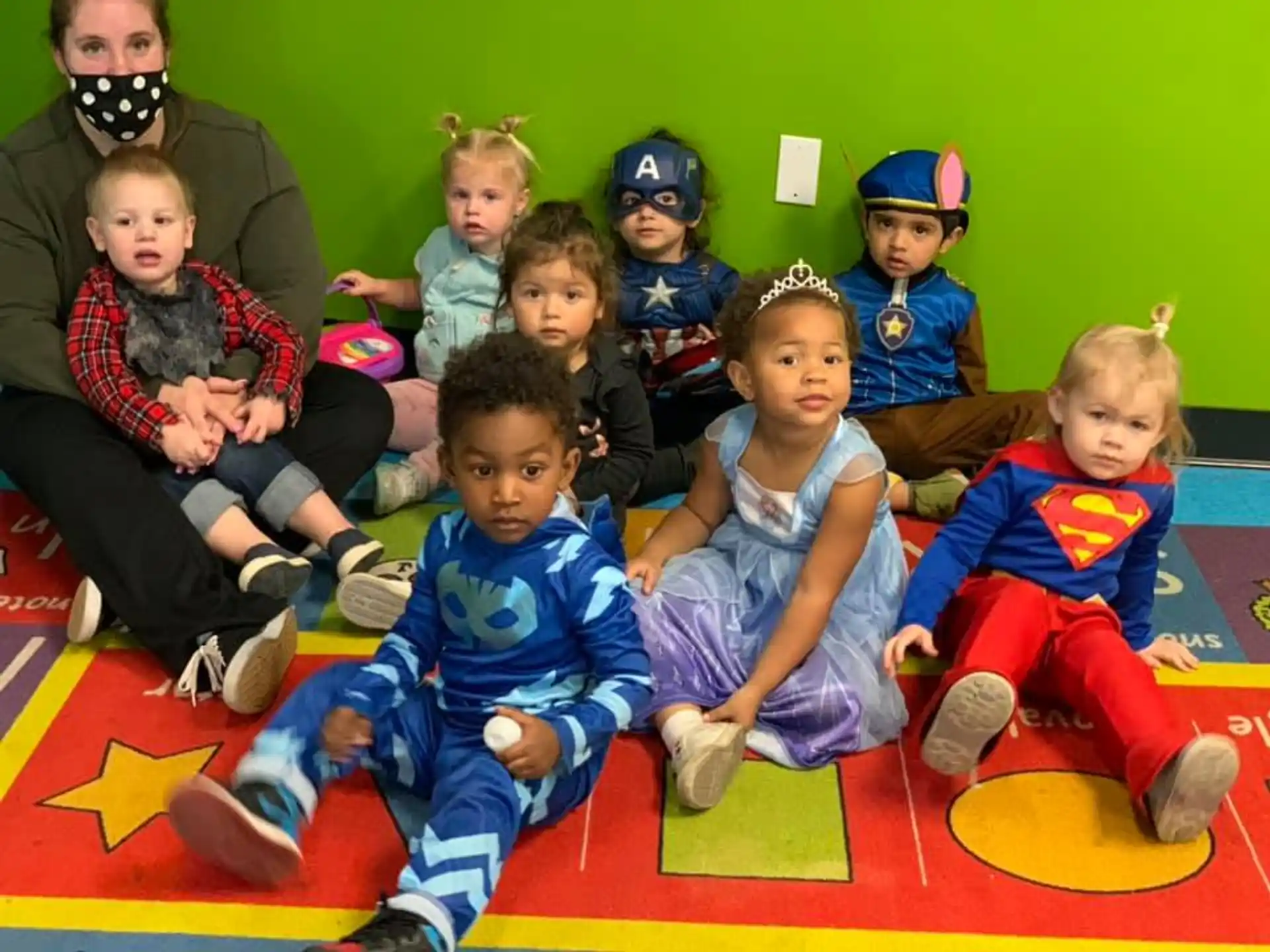 a group of children sitting on the floor posing for the camera