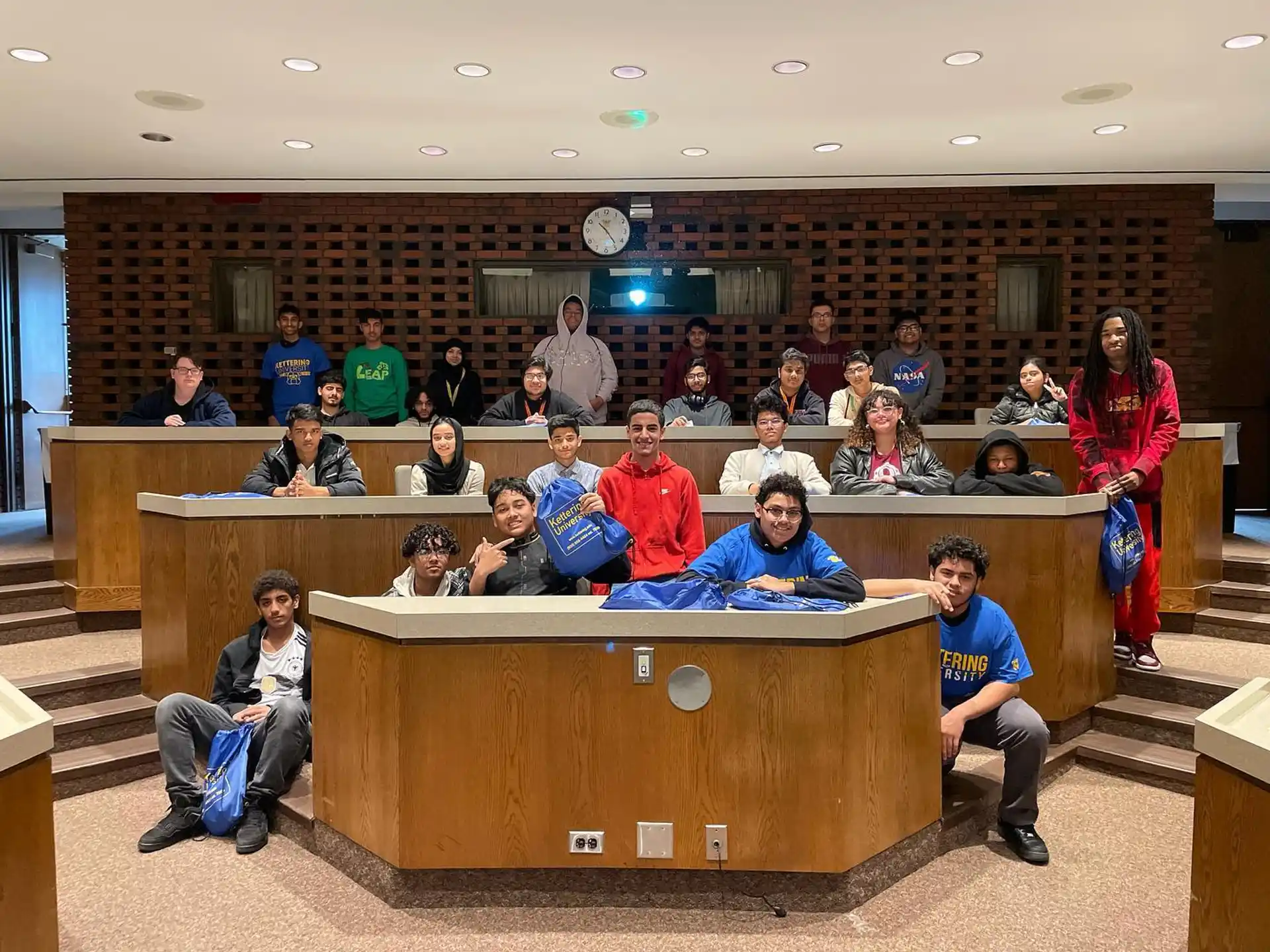 a group of people sitting at a desk in a room
