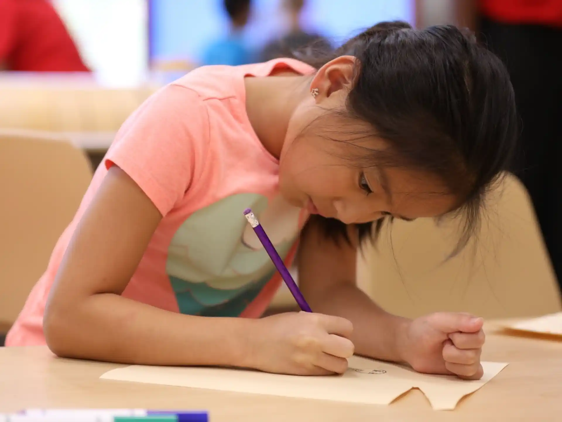 a young girl writing on a piece of paper