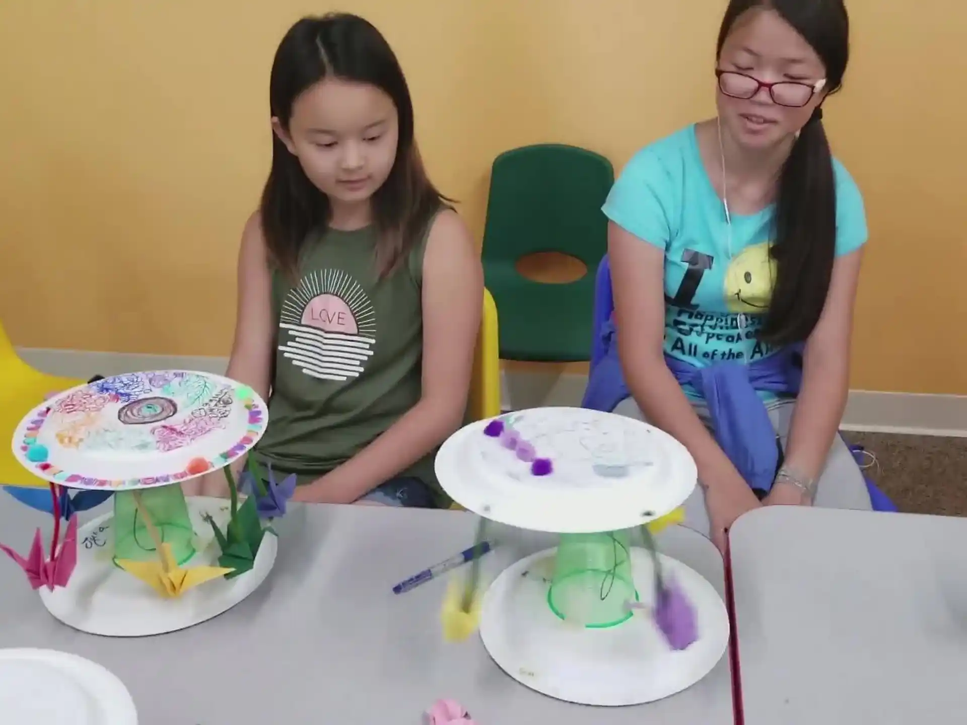 a couple of girls sitting at a table with a cake