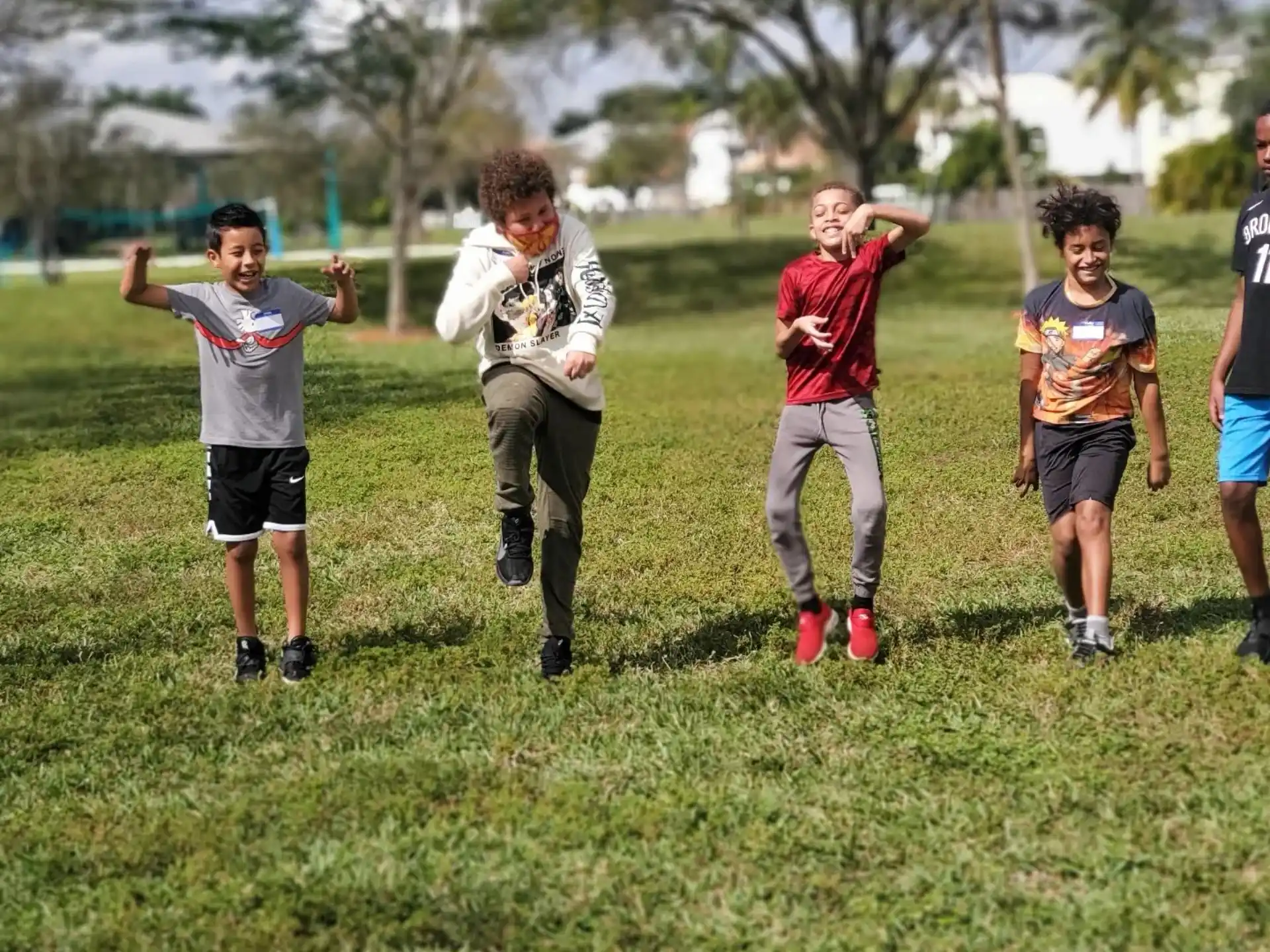 a group of people running on a grass field