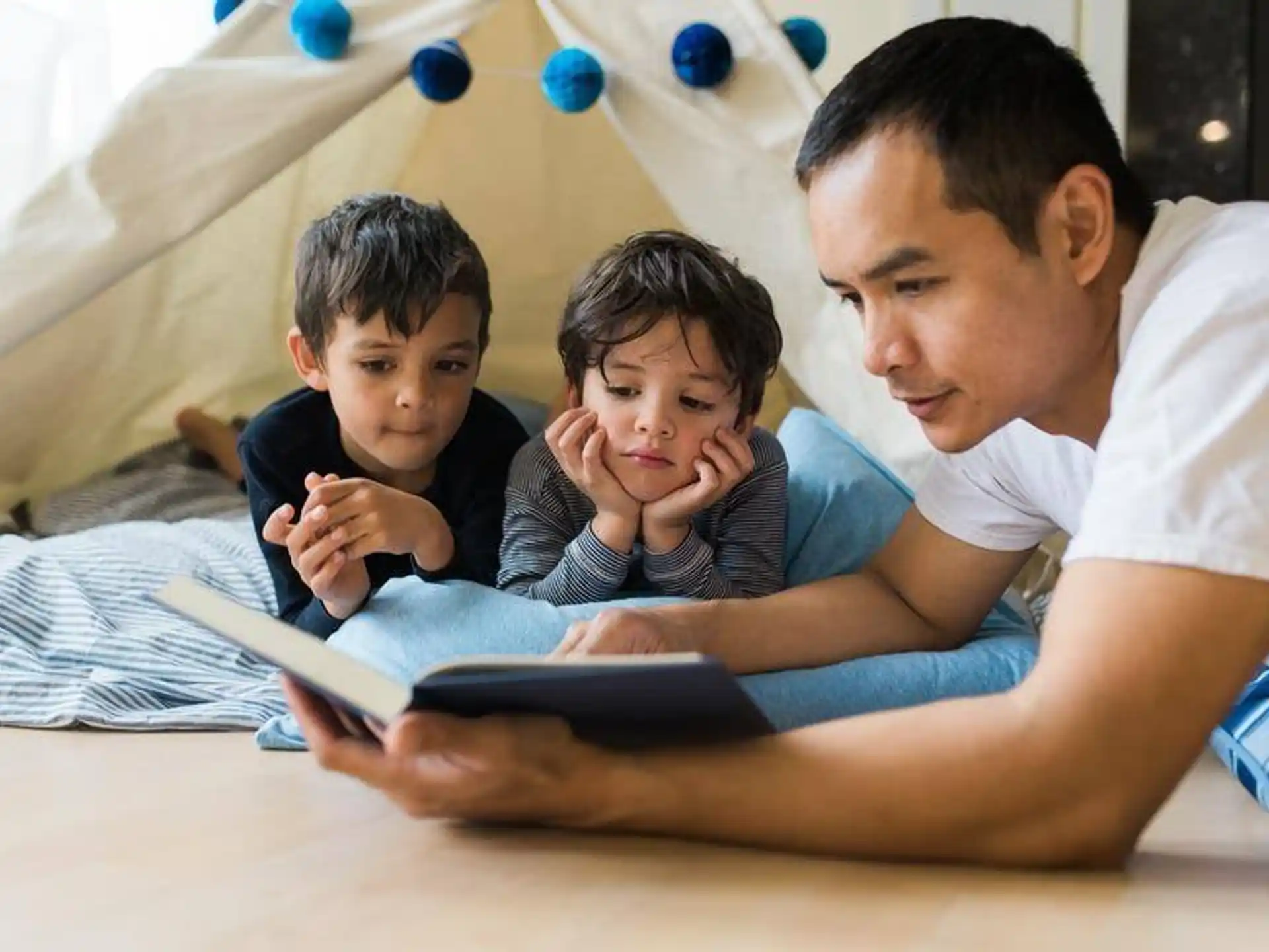 a person reading a book to a couple of children