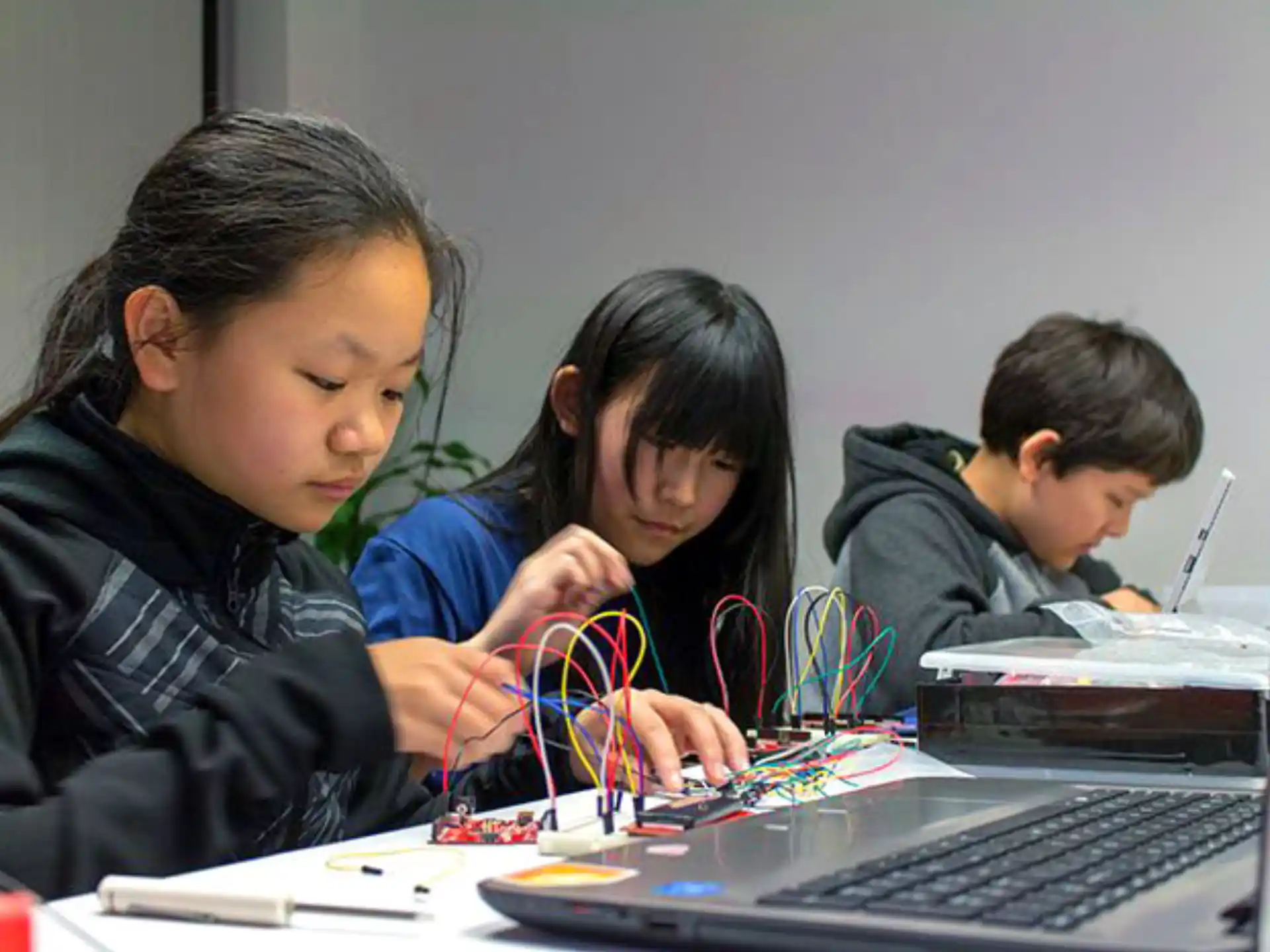 a group of kids working on a laptop