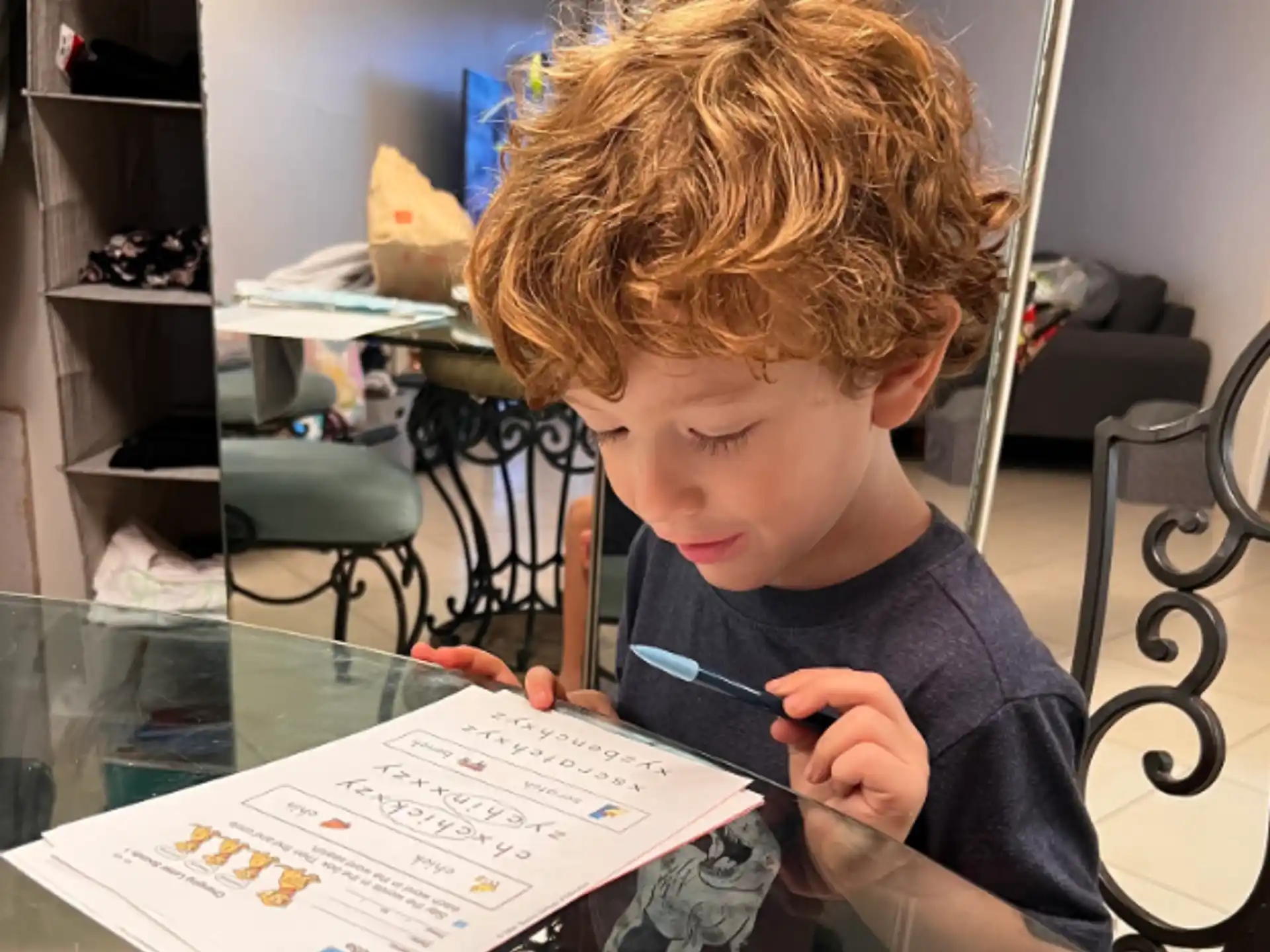 a young boy writing on a piece of paper