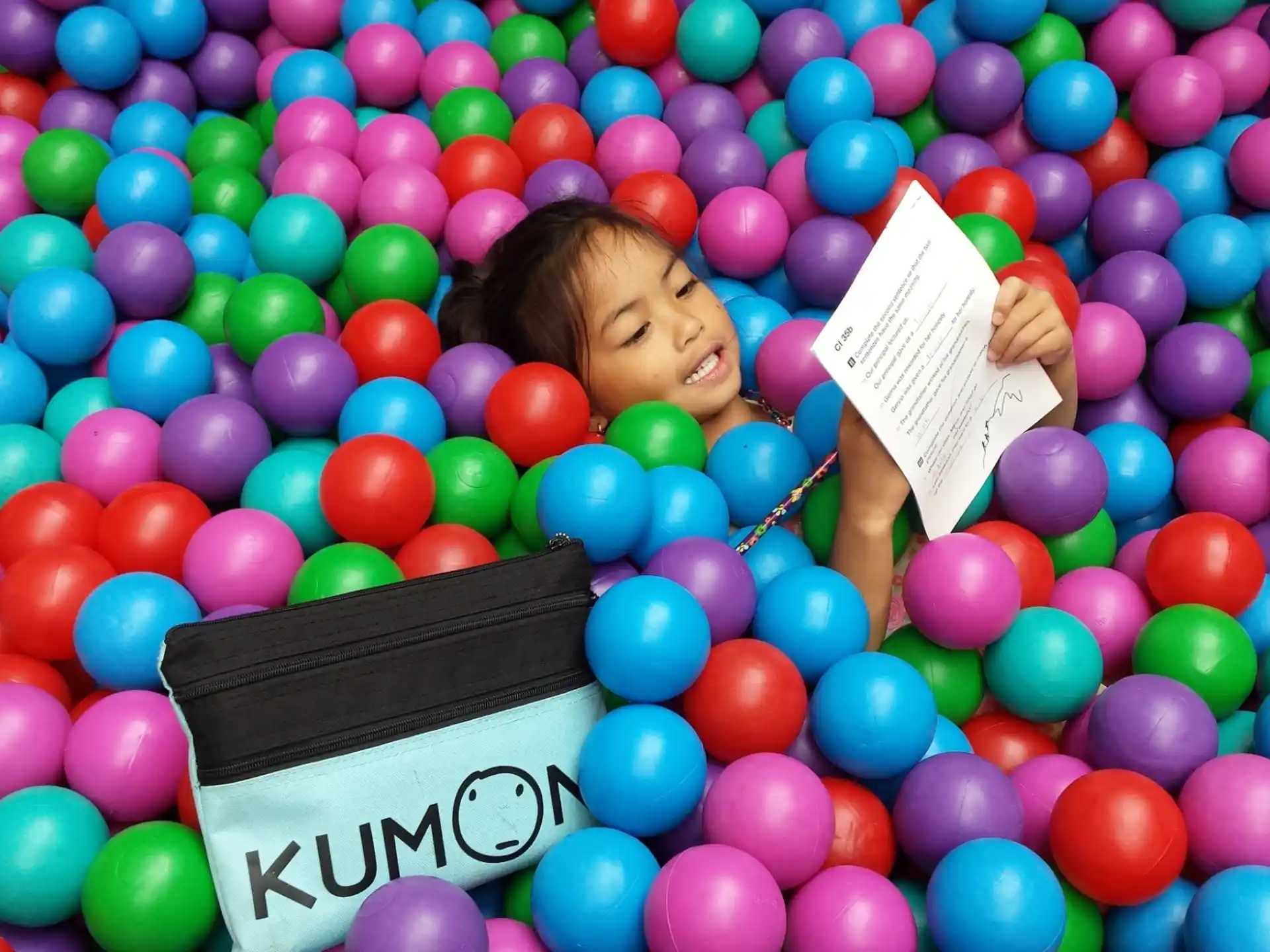 a person lying in a ball pit