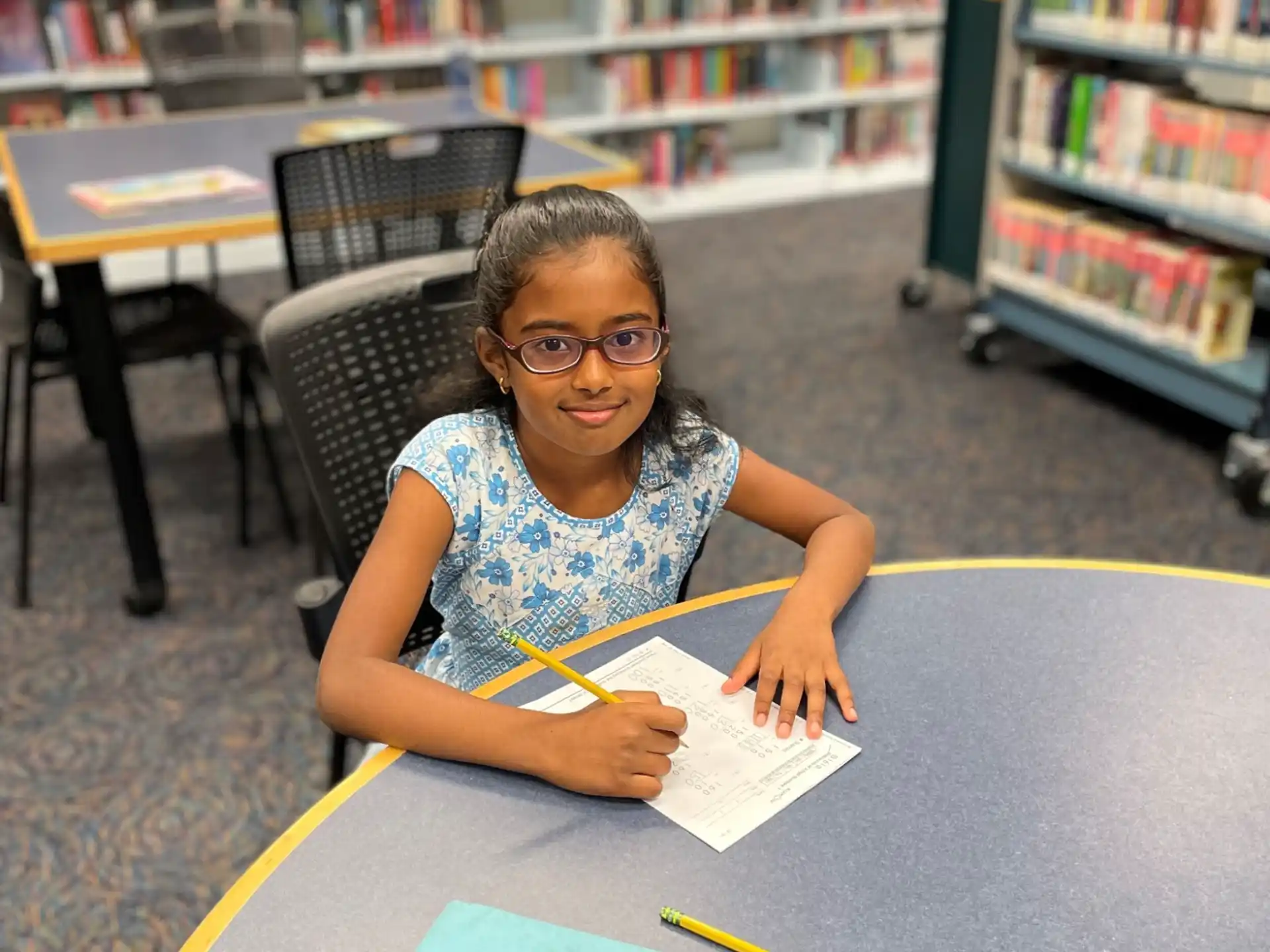 a person sitting at a table with a book and a pen