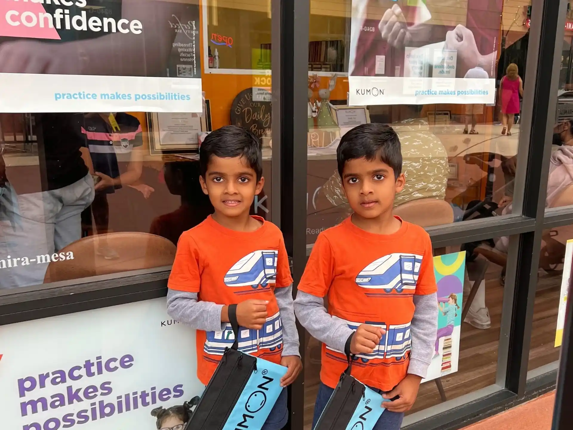 two kids standing next to a sign