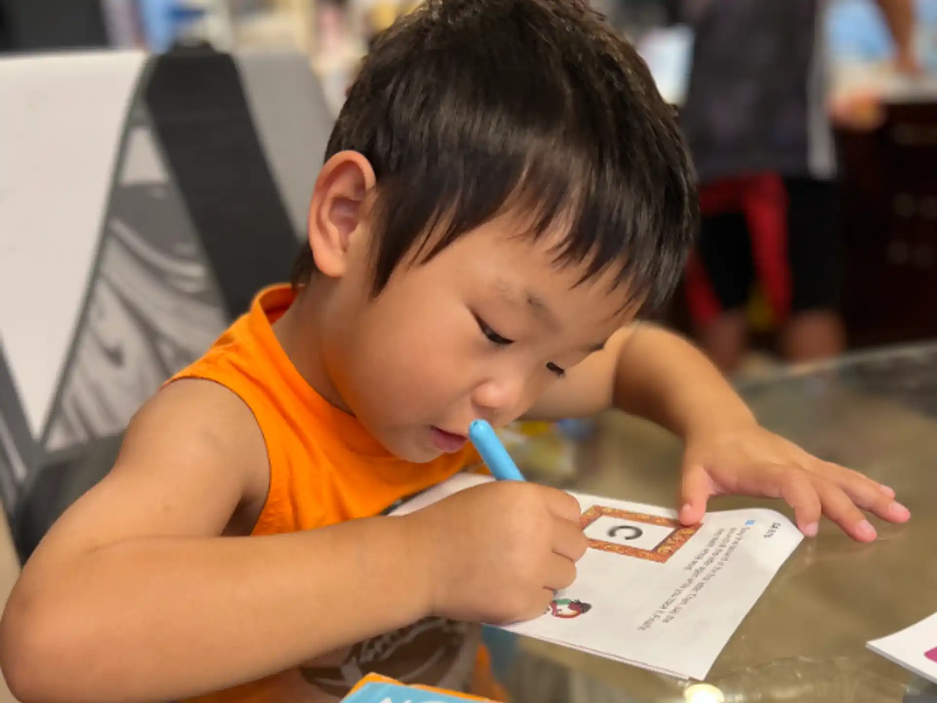 a young boy writing on a book