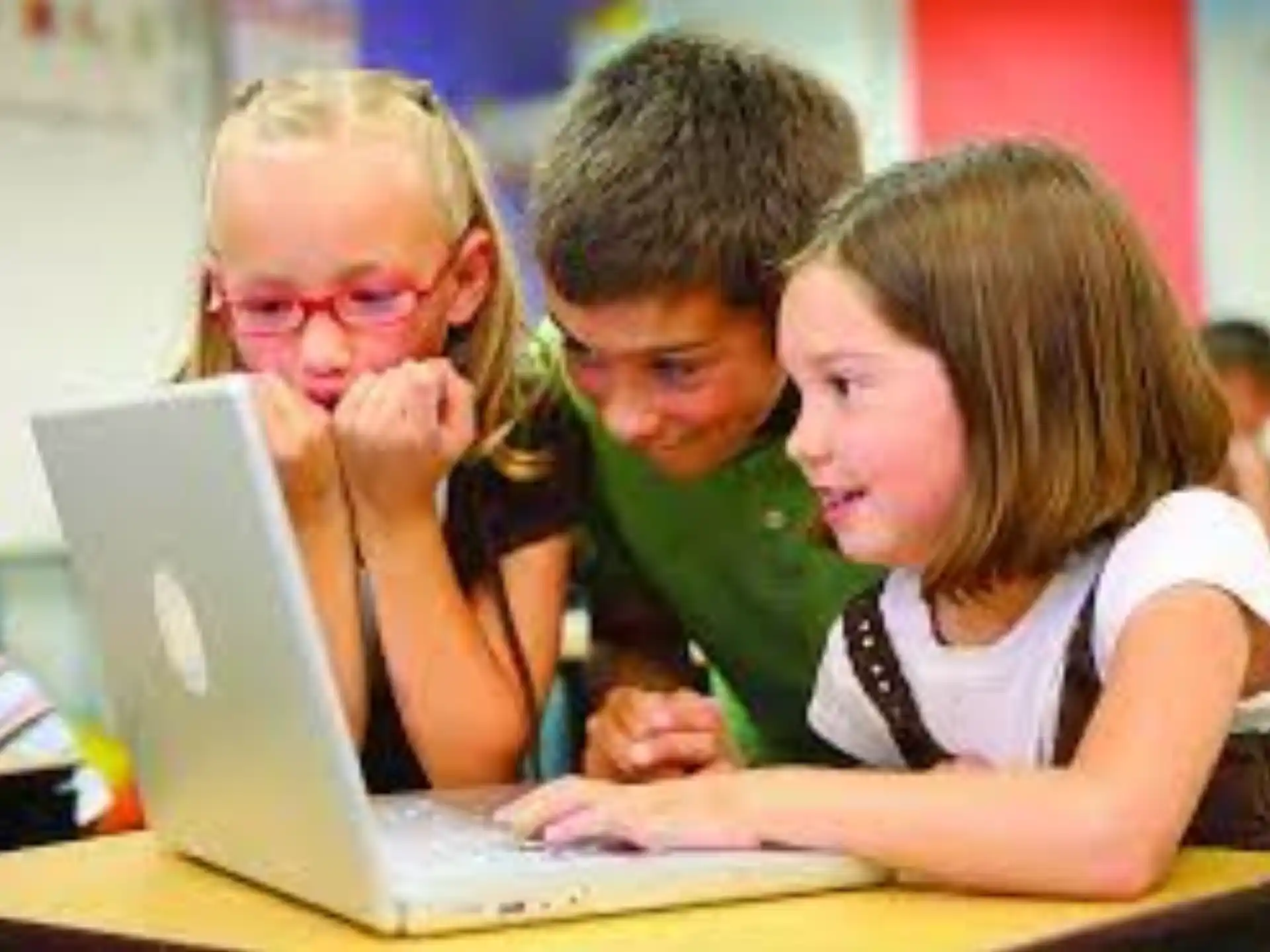 a group of people looking at a laptop