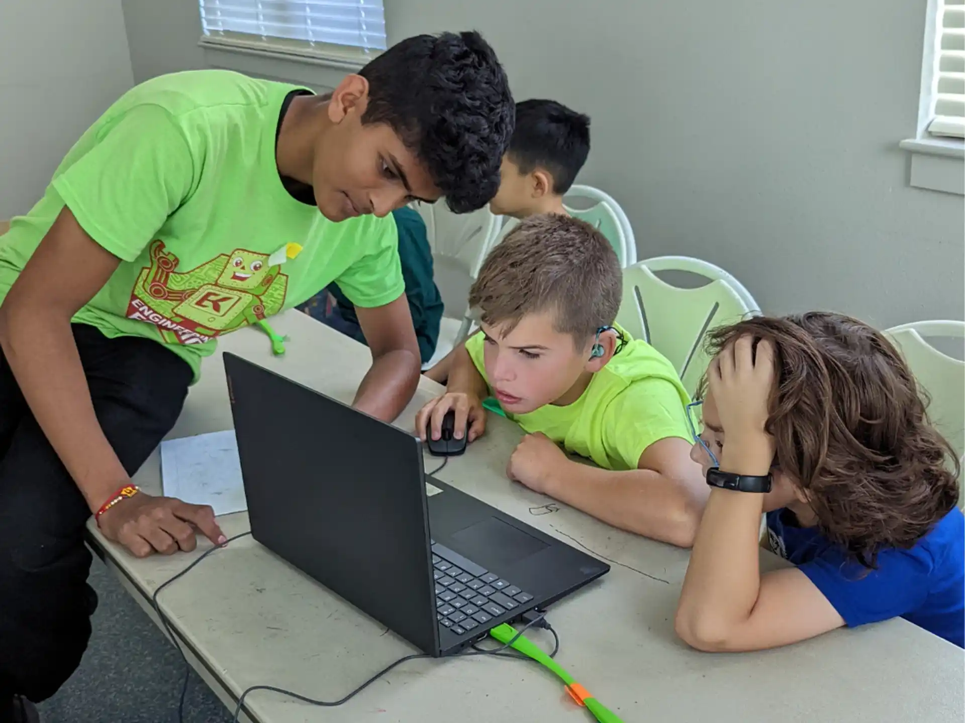 a man showing kids something on the laptop