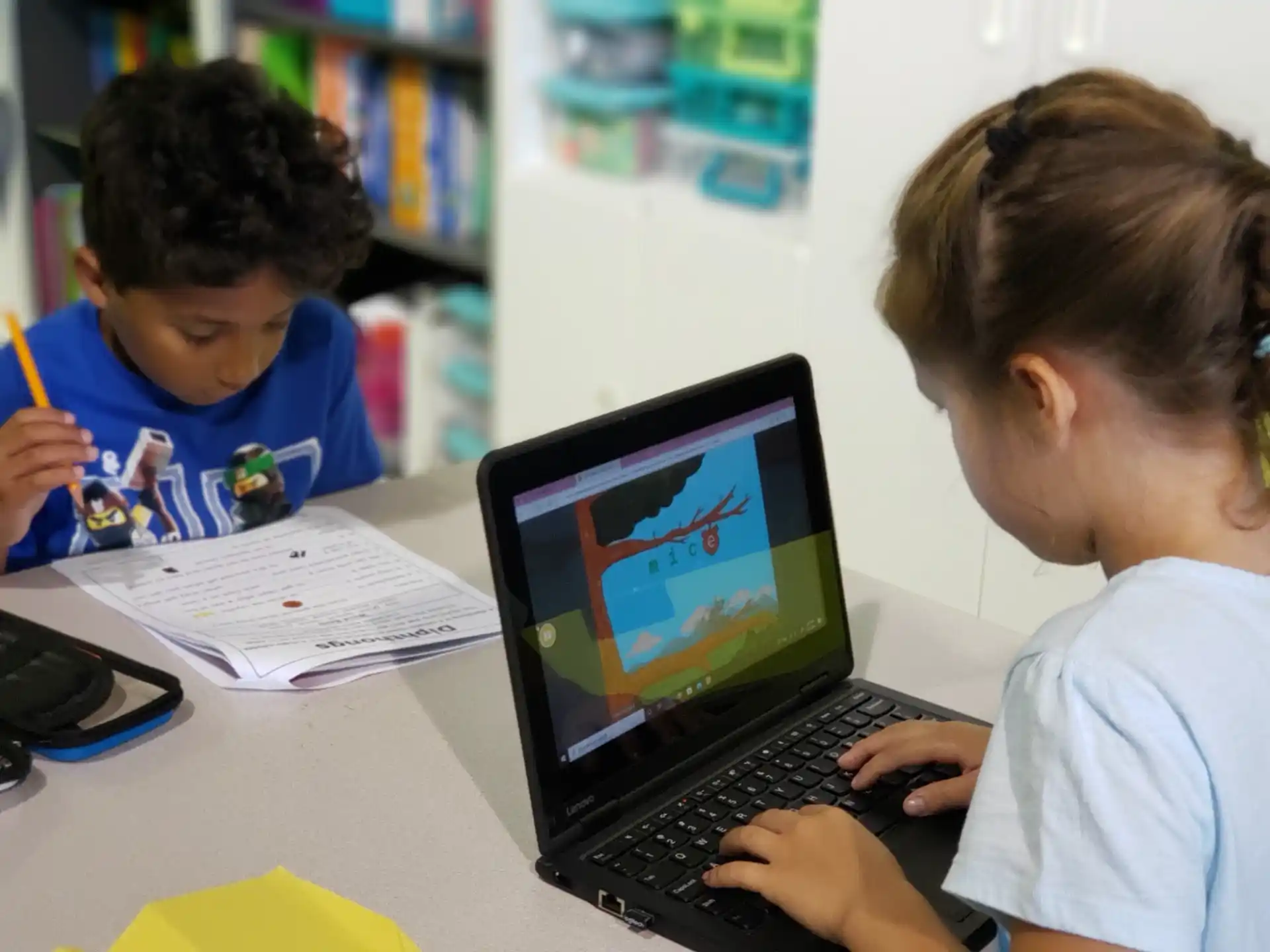 a few young boys working on a laptop