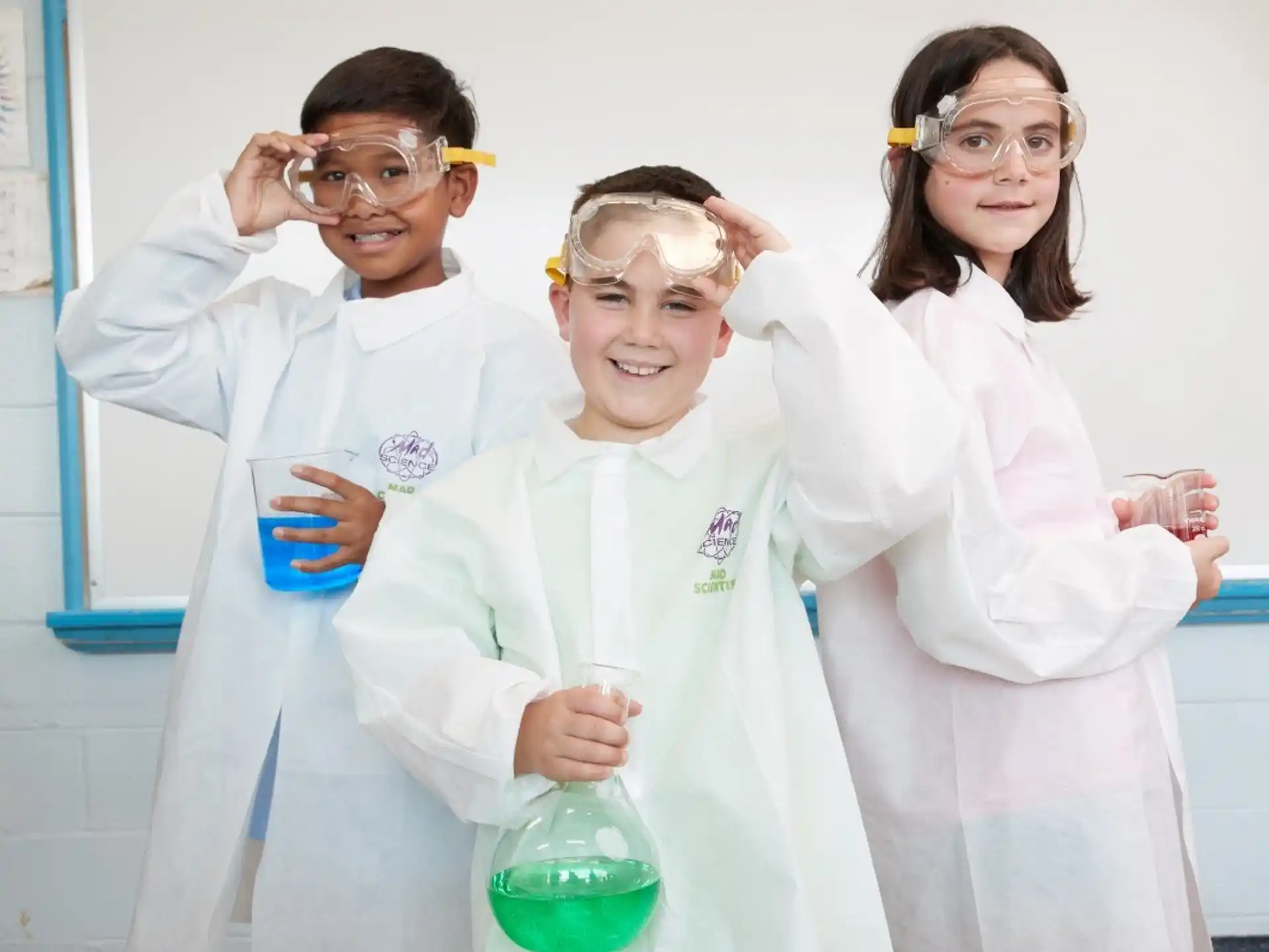 a group of people wearing lab coats and holding beakers