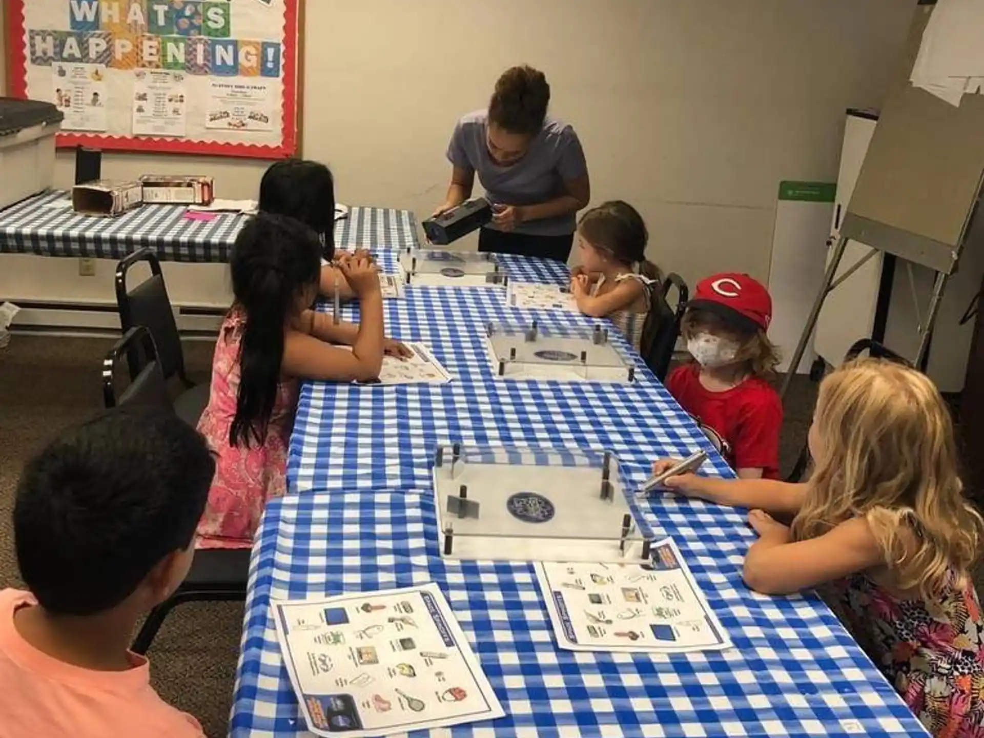 a group of children sitting around a table with a board game