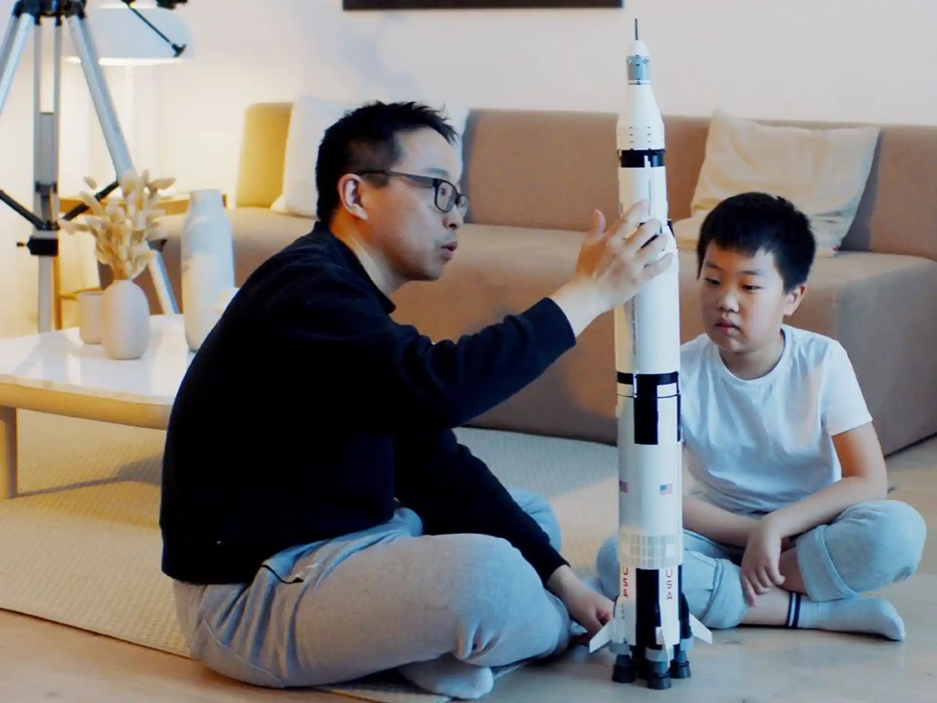 a man and a boy sitting on the floor with a sword