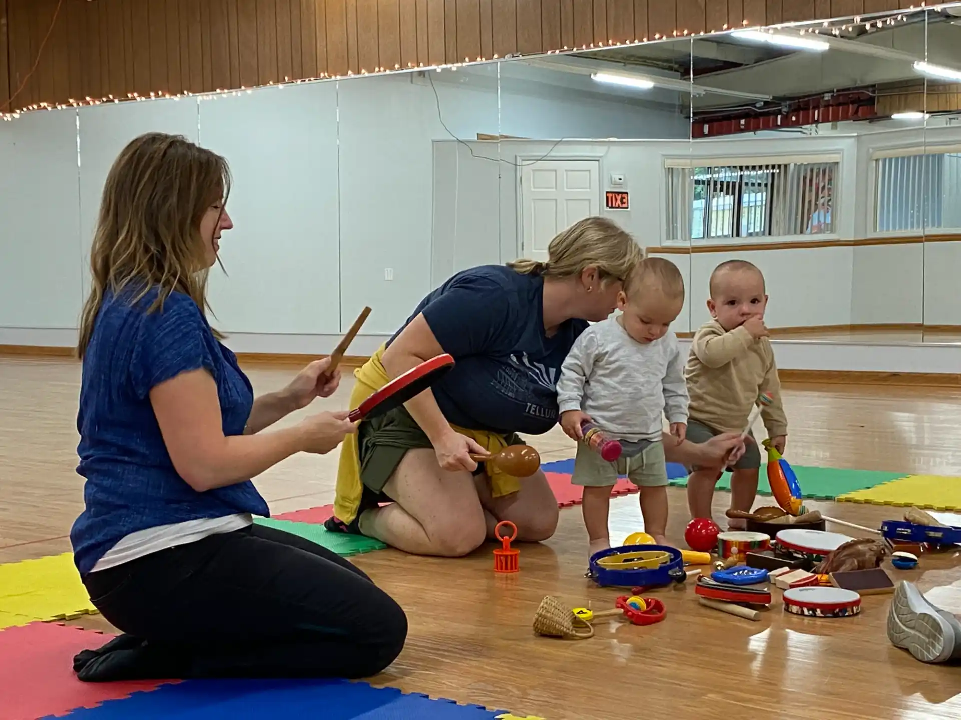 a person and two children playing with toys in a room