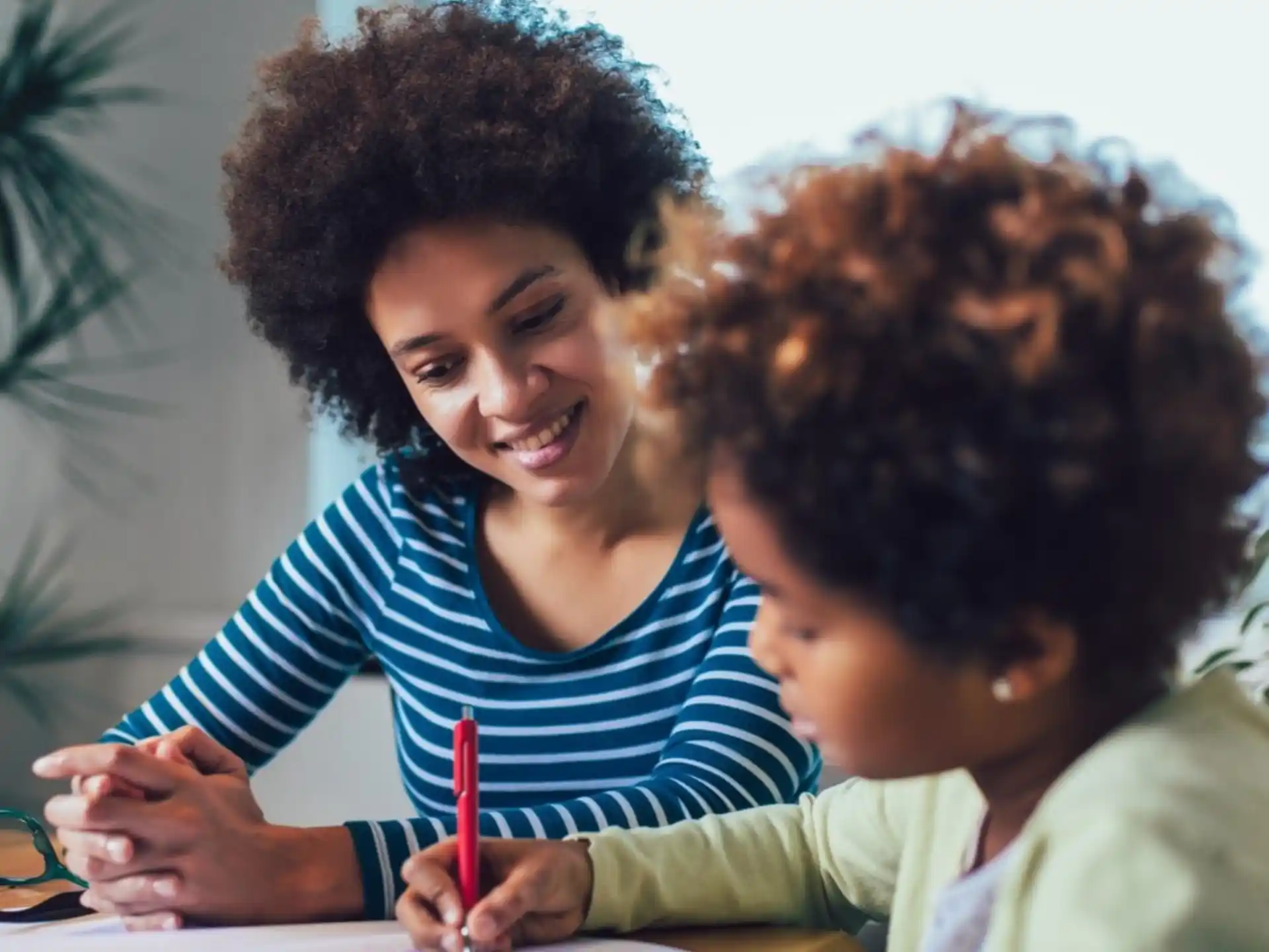 a person and a child looking at a paper