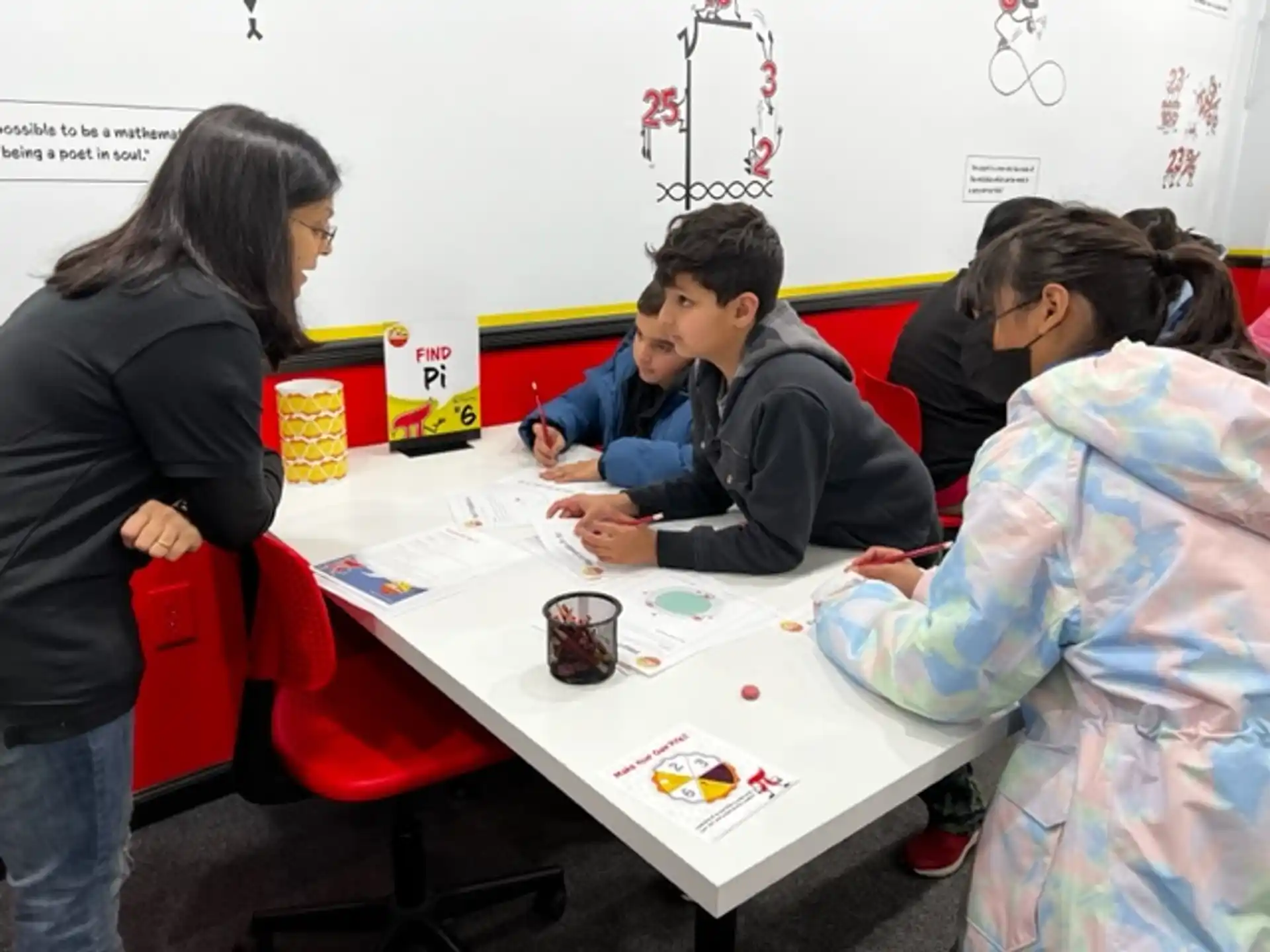 a group of people sitting at a table with a white board